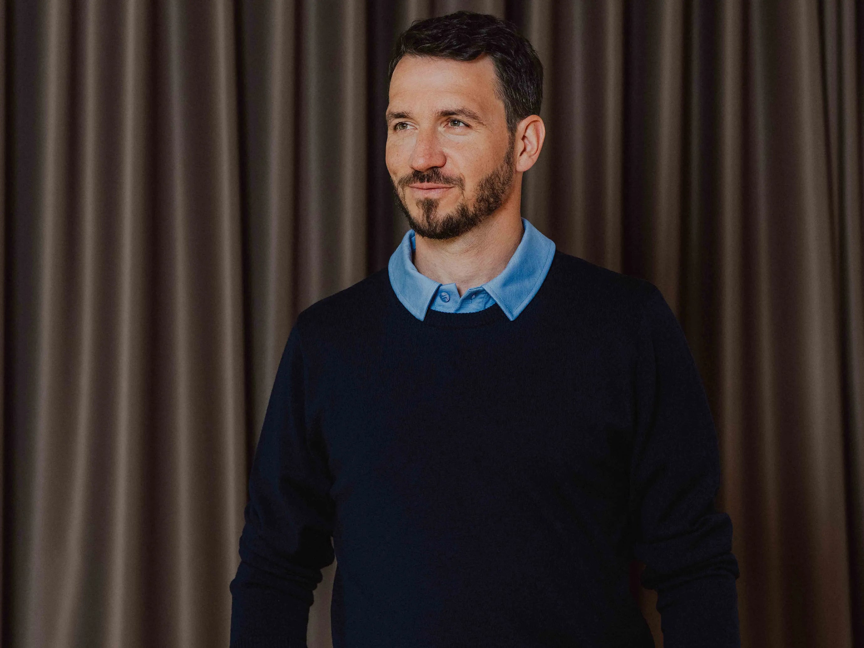Felix Neureuther im dunkelblauen TOM FYFE Merino Pullover Herren über einem hellblauen Merino Polo Herren.