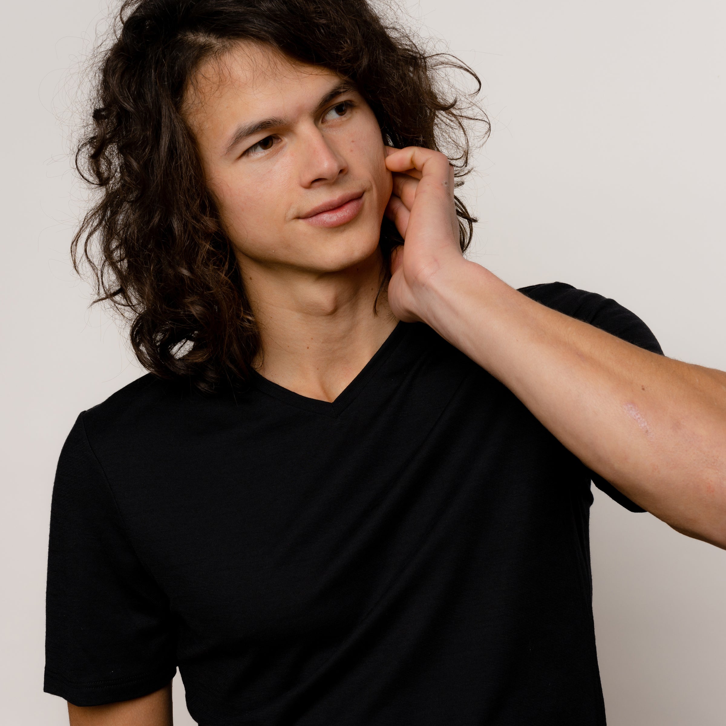 Model mit seidig weichem Herren Merino T-Shirt mit V-Ausschnitt in Schwarz von Tom Fyfe