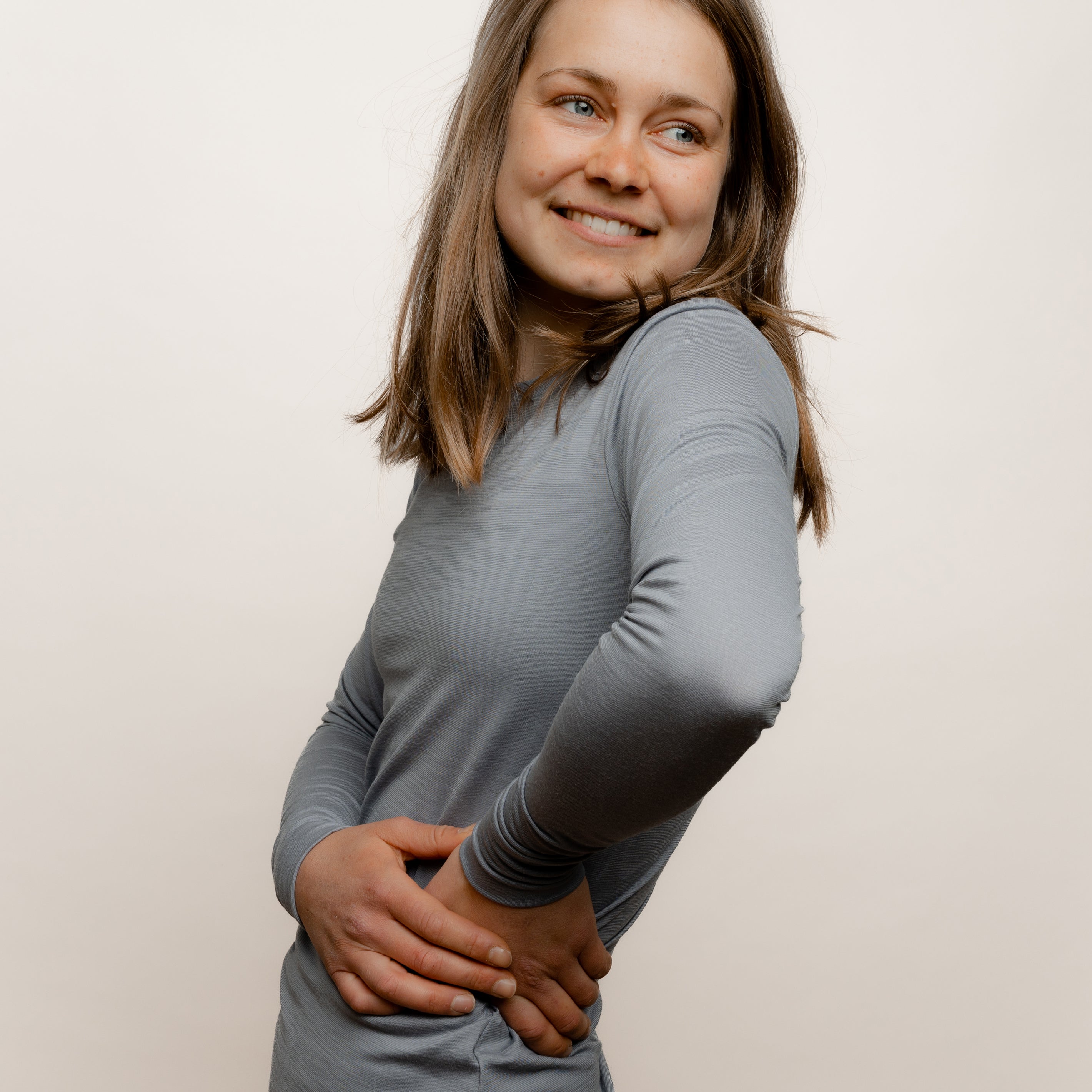 Model mit Merino Damen Langarmshirt Seitenansicht von TOM FYFE in Hellgrau