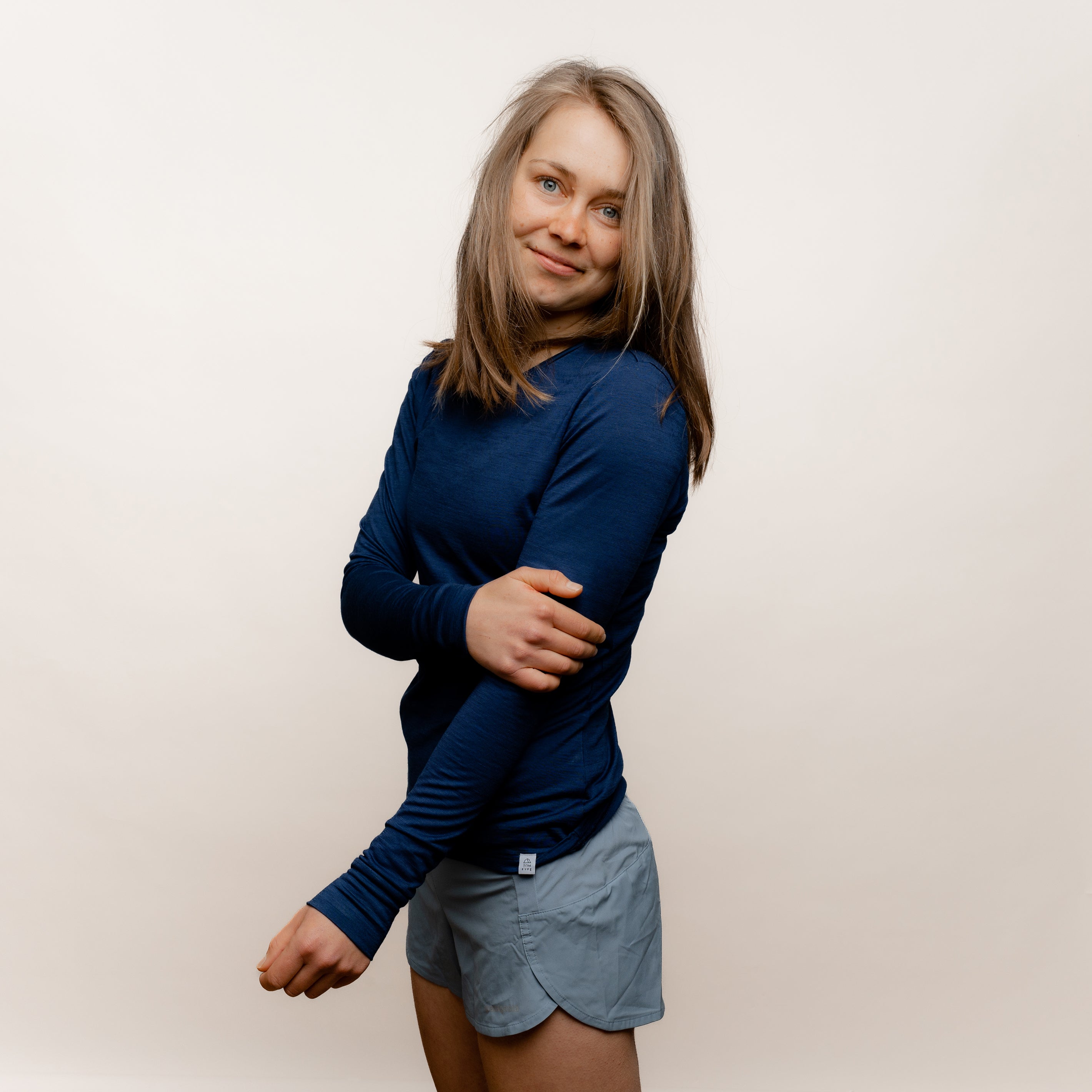Model mit Merino Damen Langarmshirt Seitenansicht von Tom Fyfe in Marine