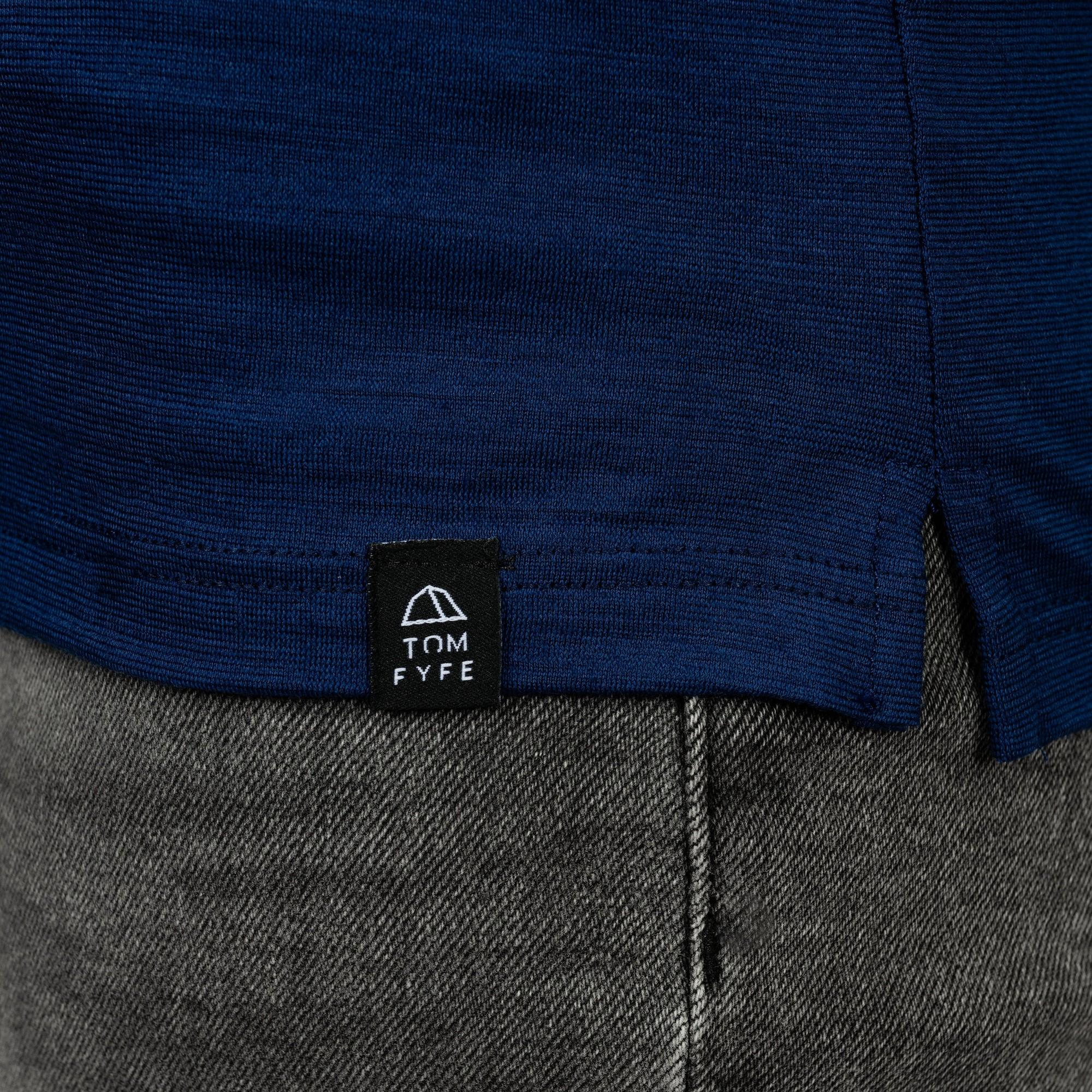 Model mit Merino Damen Poloshirt Label von TOM FYFE in Marine