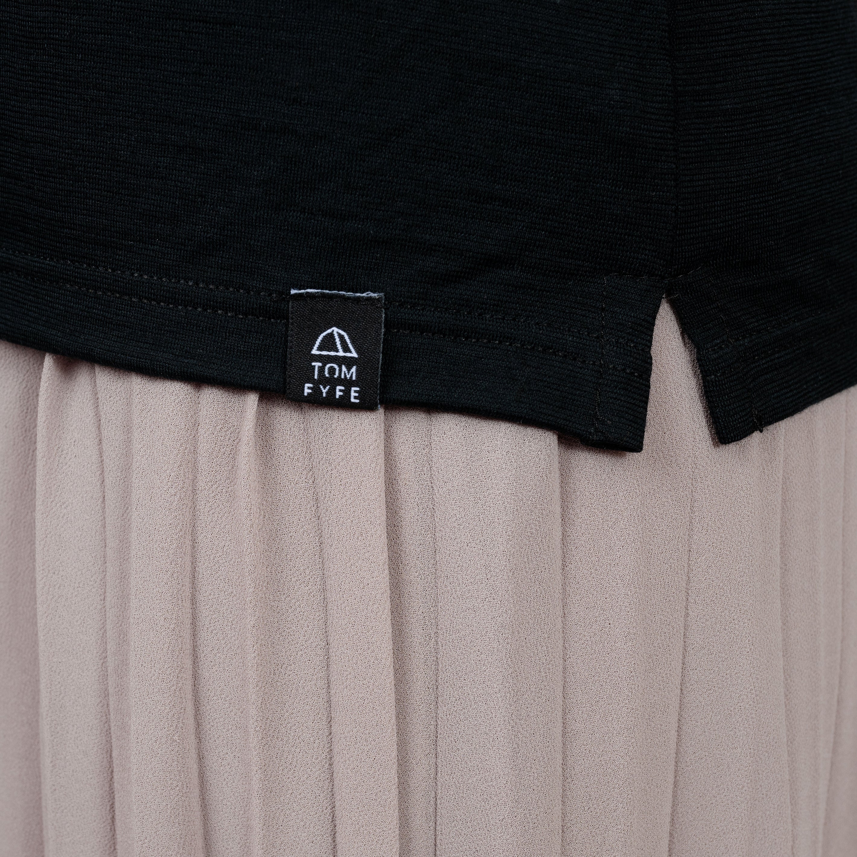Model mit Merino Damen Poloshirt Label von Tom Fyfe in Schwarz