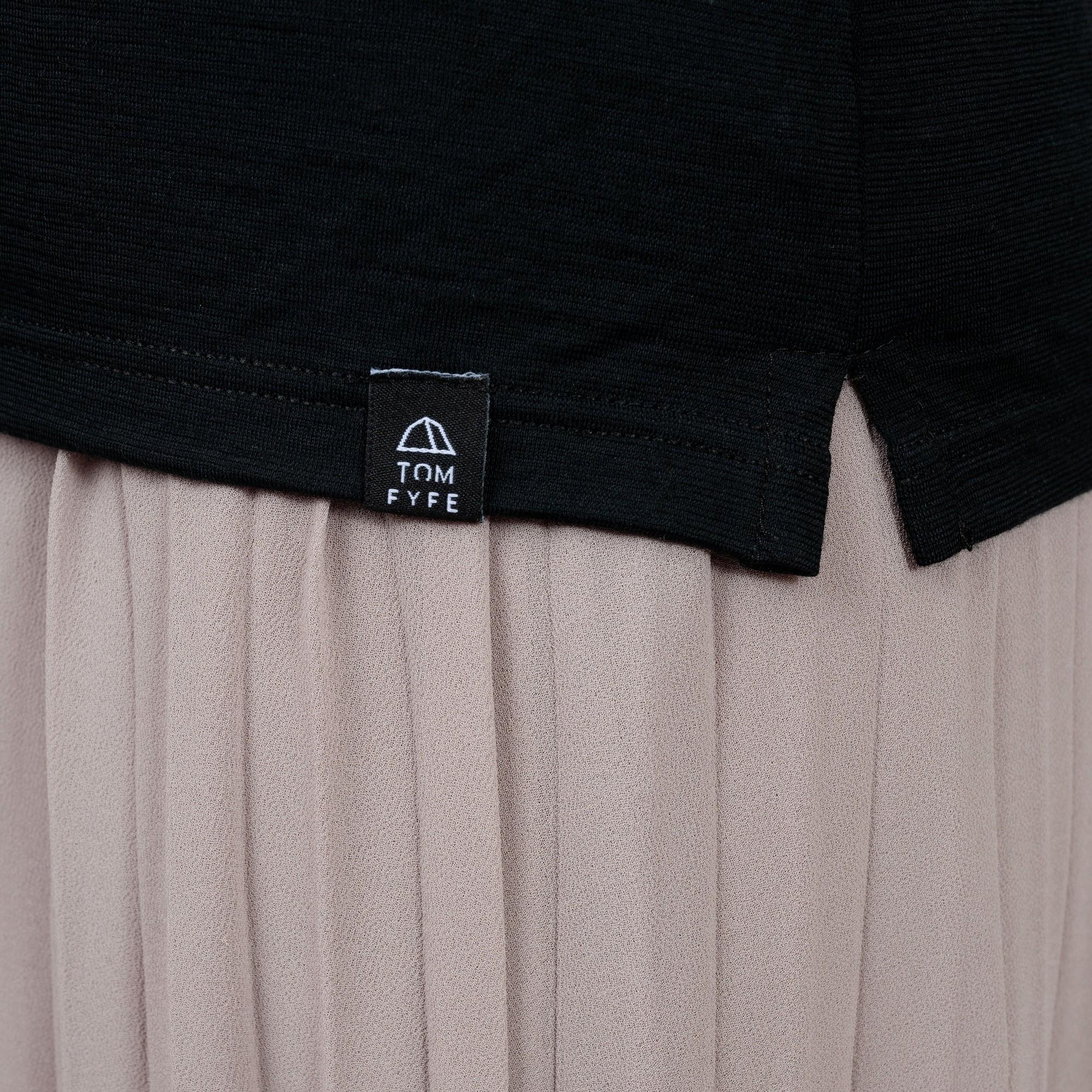 Model mit Merino Damen Poloshirt Label von TOM FYFE in Schwarz