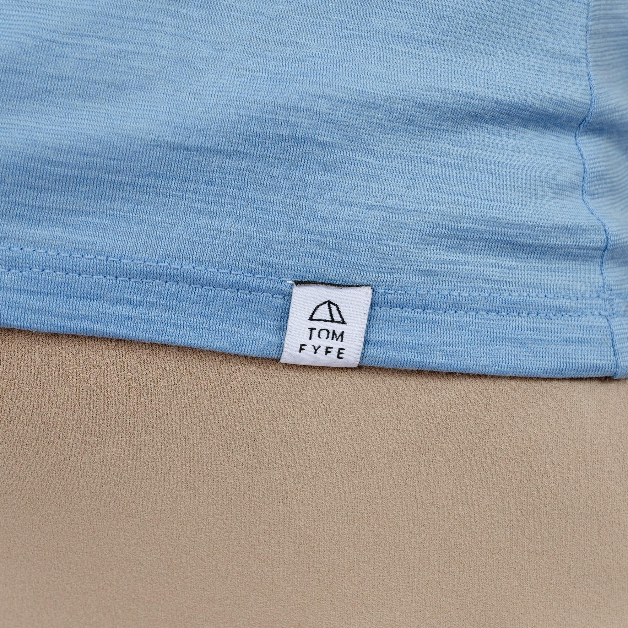 Model mit Merino Damen Shirt mit angenaehtem Stofflabel mit Logo von TOM FYFE in Steelblue