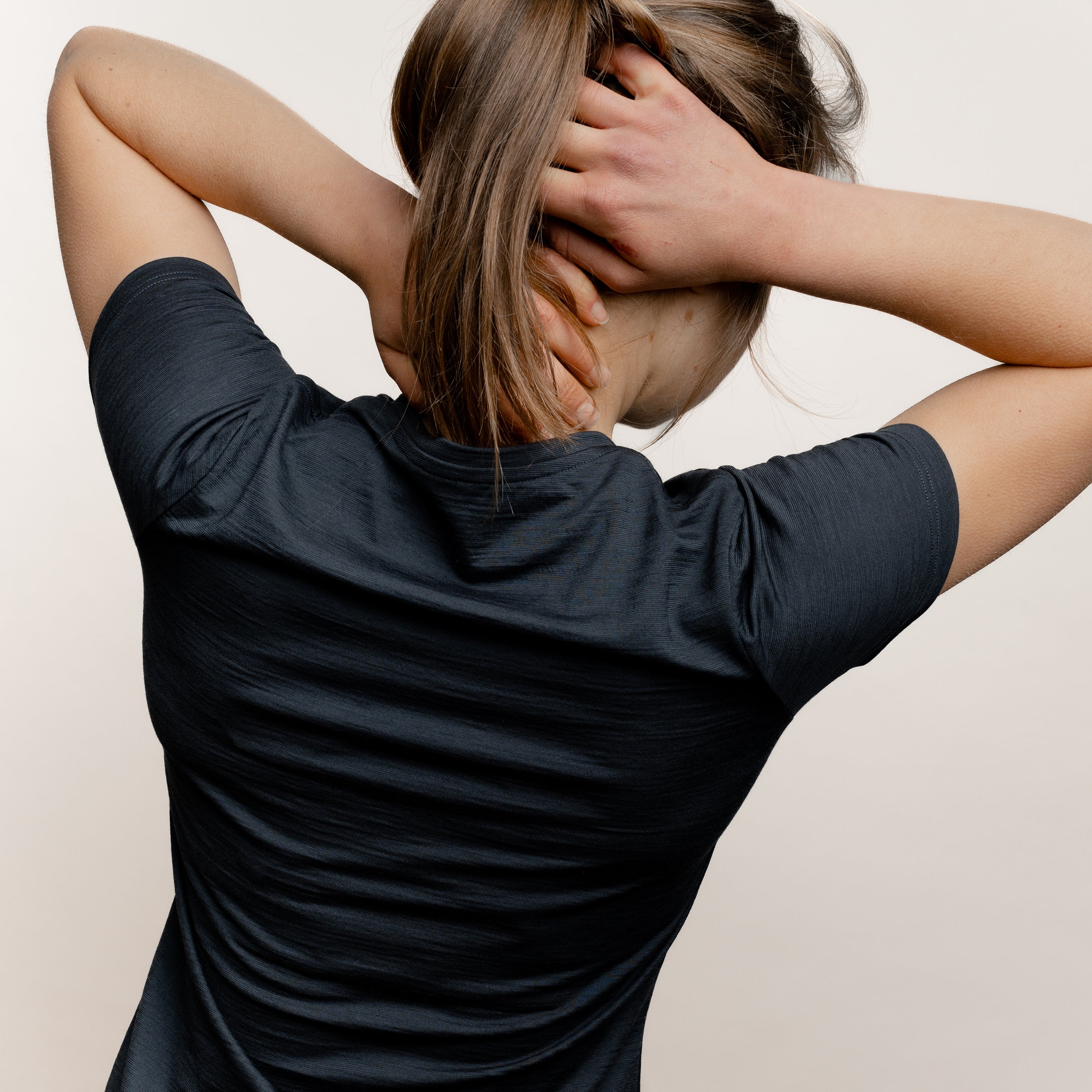 Model mit Merino Damen Shirt mit V-Ausschnitt von Tom Fyfe in Anthrazit Rückansicht