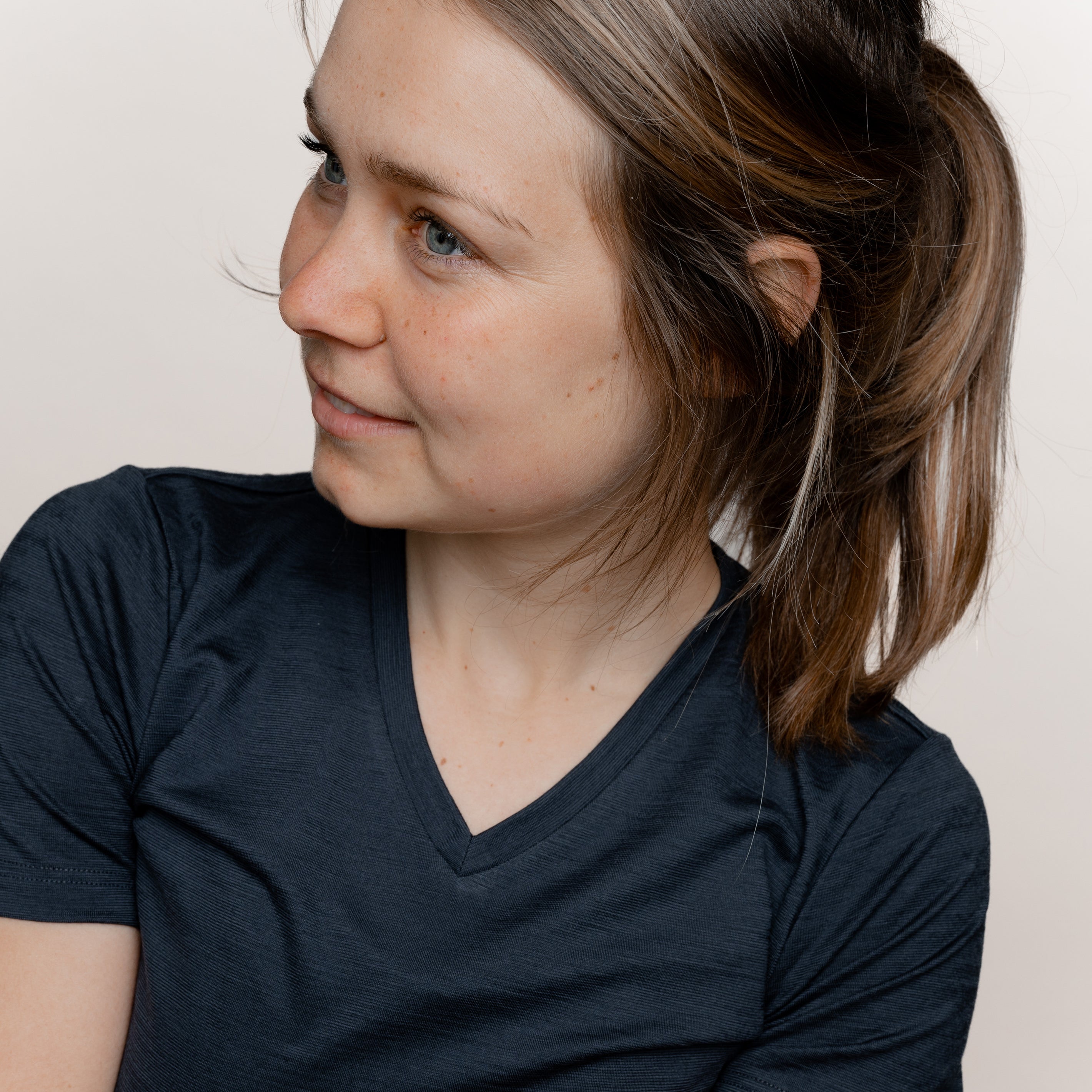 Model mit Merino Damen Shirt mit V-Ausschnitt von Tom Fyfe in Anthrazit Nahaufnahme Arm Brust Bereich