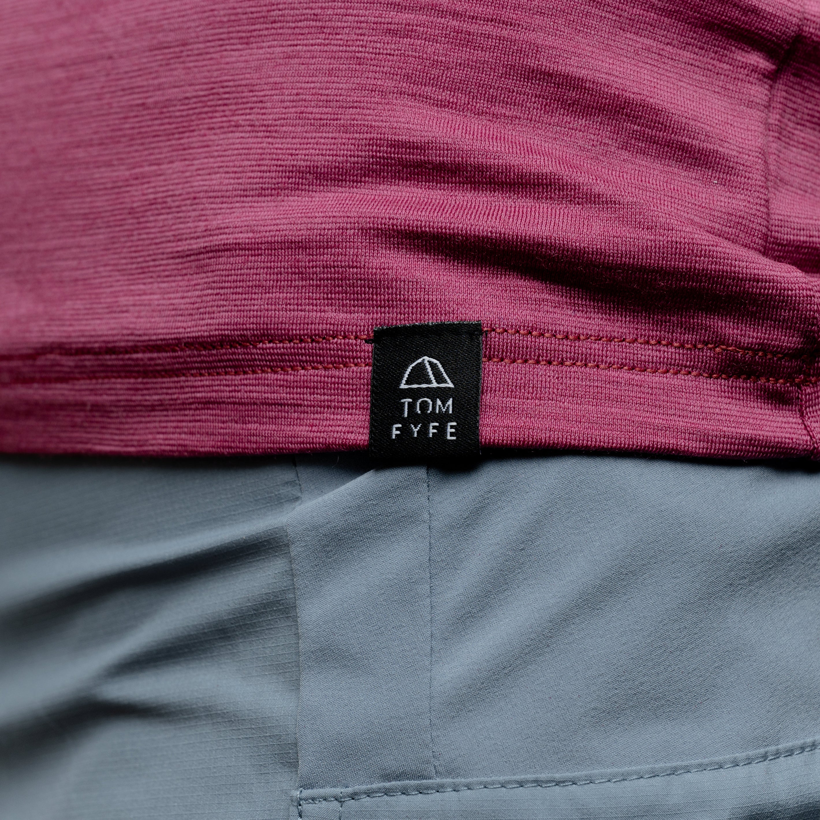 Merino Damen Shirt mit V-Ausschnitt von Tom Fyfe in Brombeere mit angenähtem Stofflabel mit Logo