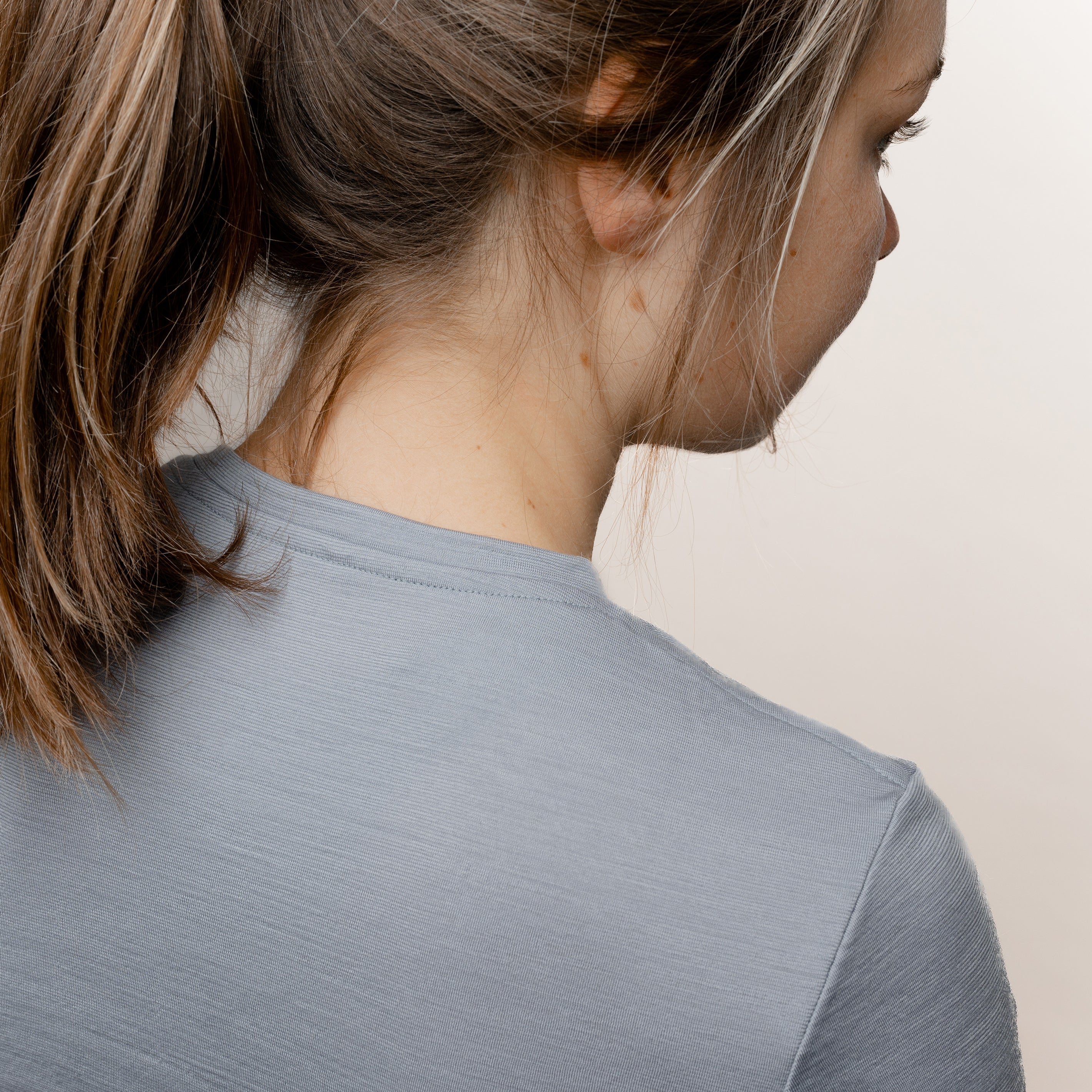 Model mit Merino Damen Shirt mit V-Ausschnitt von Tom Fyfe in Hellgrau Nahaufnahme Nacken Schulter Bereich
