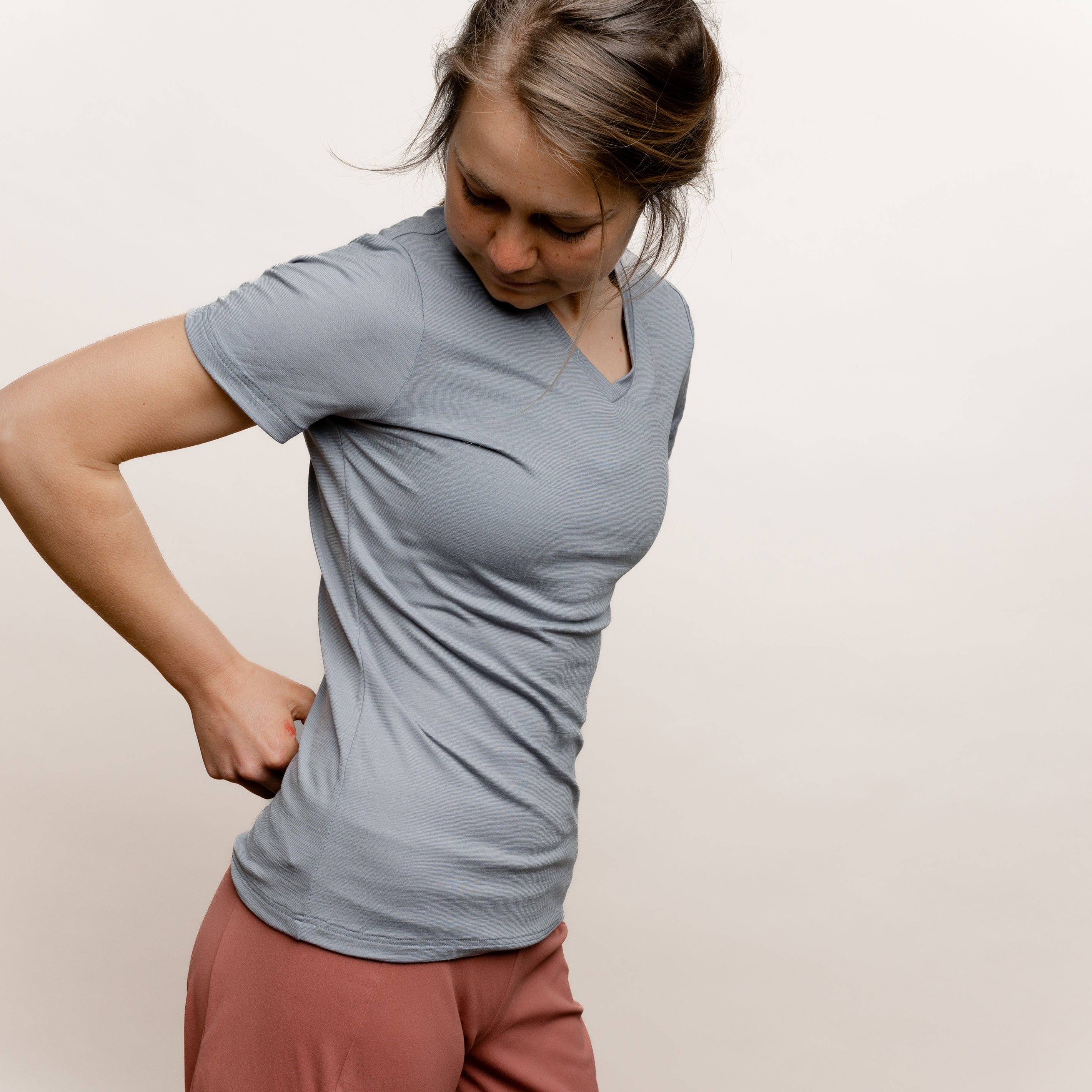 Model mit Merino Damen Shirt mit V-Ausschnitt von Tom Fyfe in Hellgrau Seitenansicht