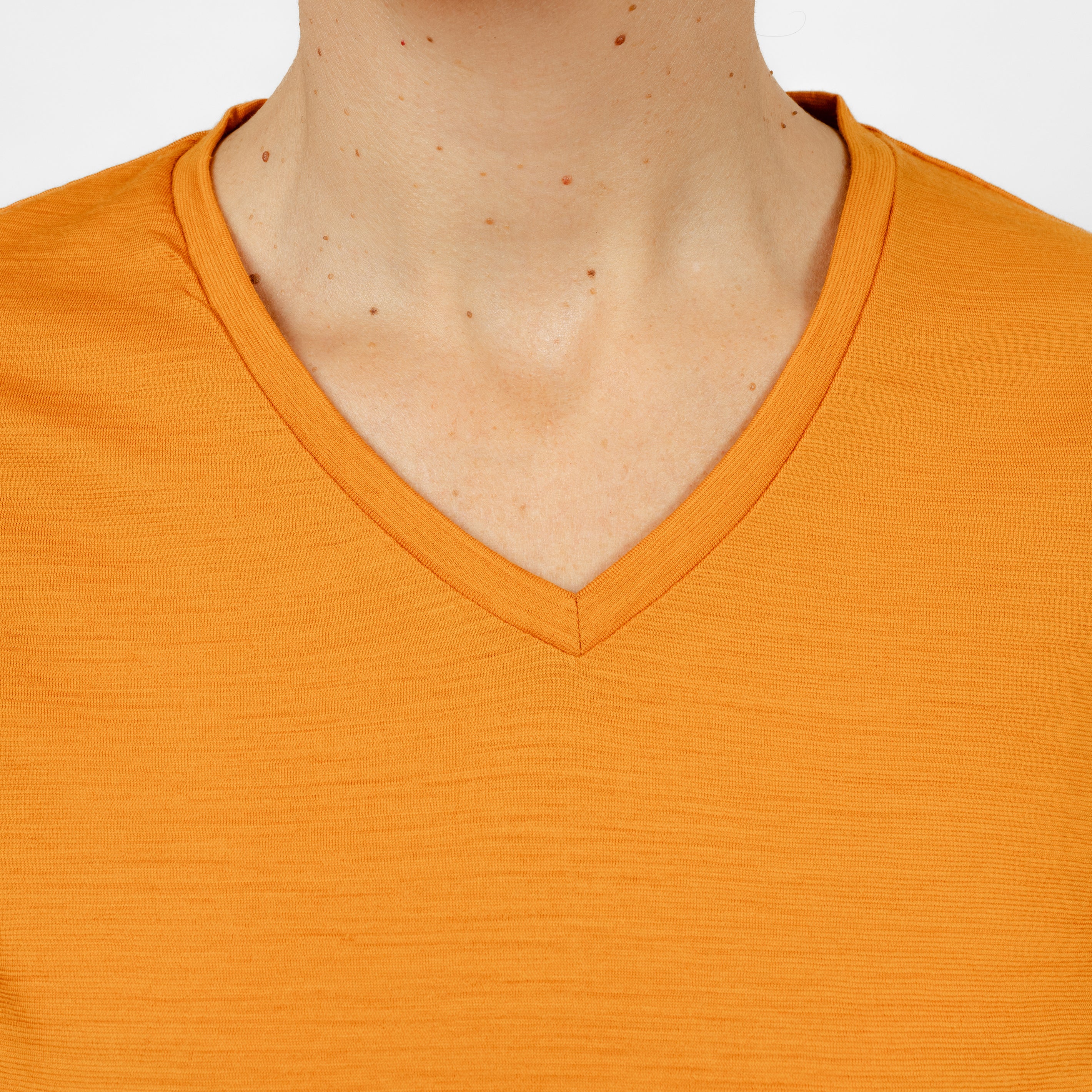 Model mit Merino Damen Shirt mit V-Ausschnitt von Tom Fyfe Nahaufnahme Kragen in Kurkuma
