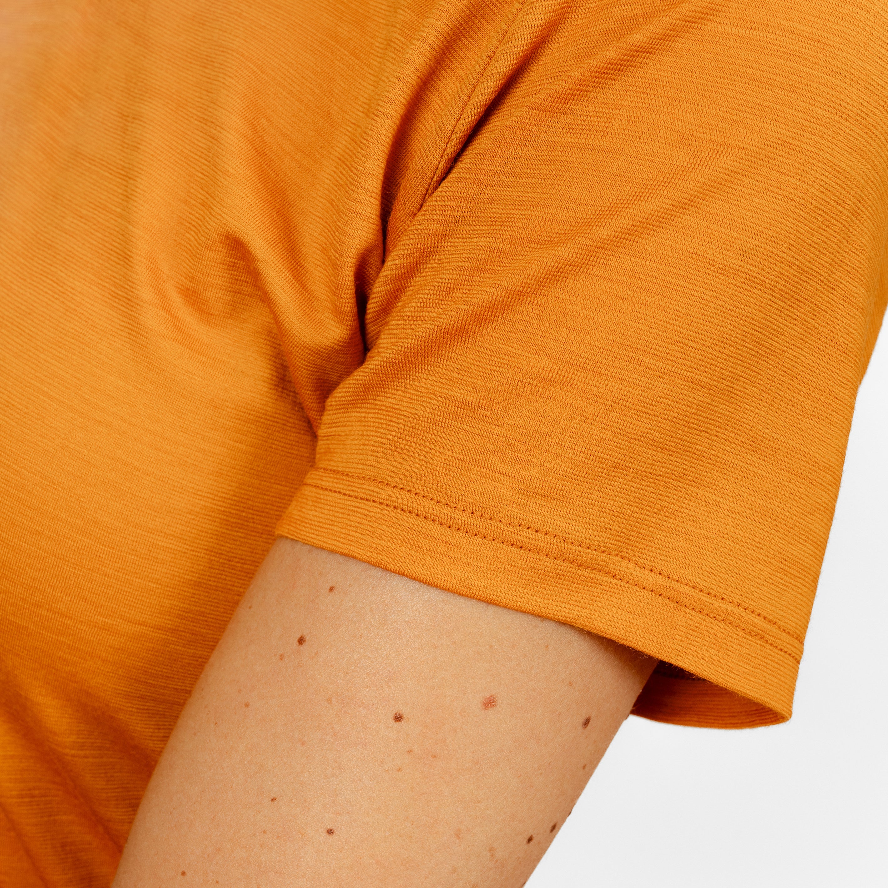 Model mit Merino Damen Shirt mit V-Ausschnitt von Tom Fyfe Nahaufnahme Ärmel in Kurkuma
