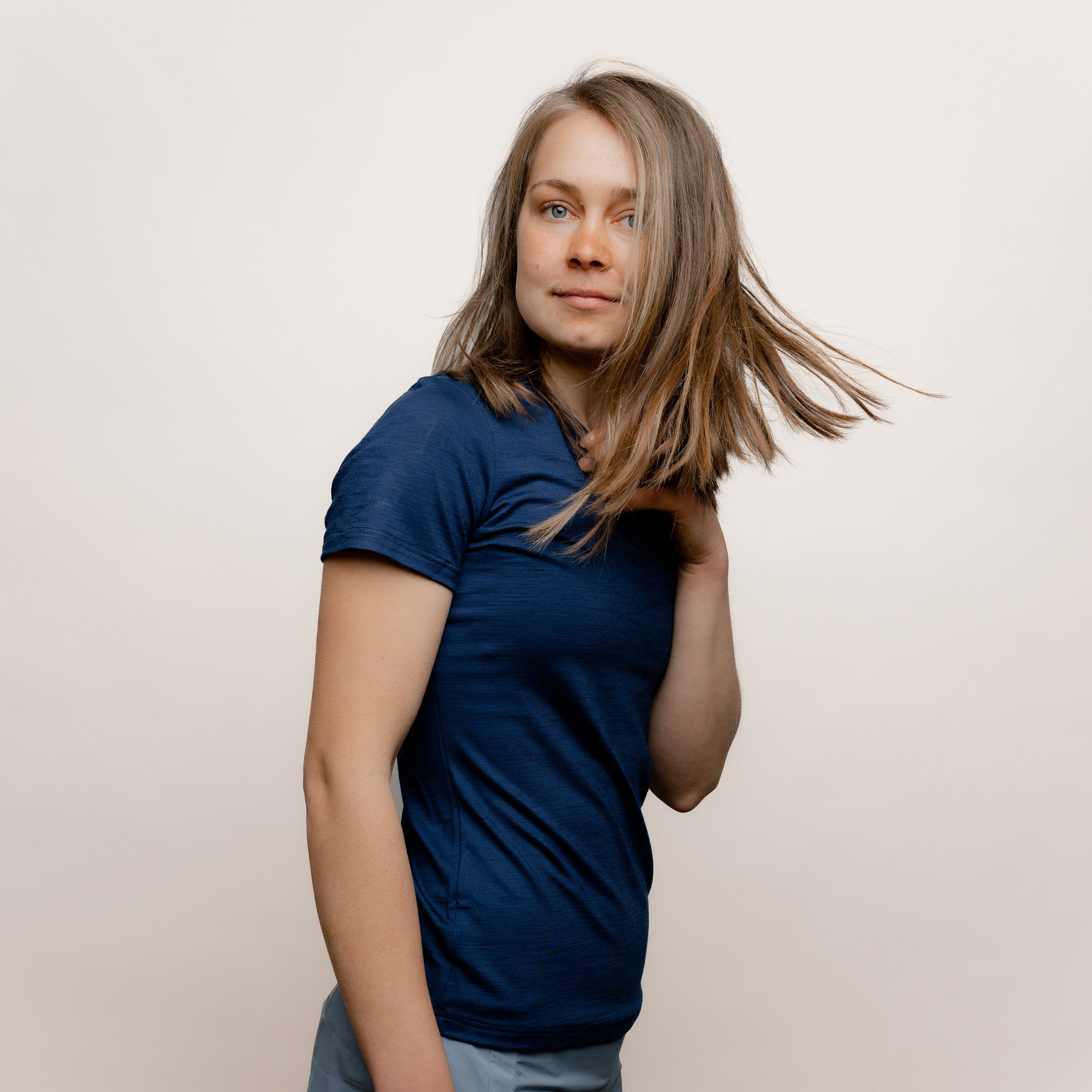 Model mit Merino Damen Shirt mit V-Ausschnitt von Tom Fyfe in Marine Seitenansicht