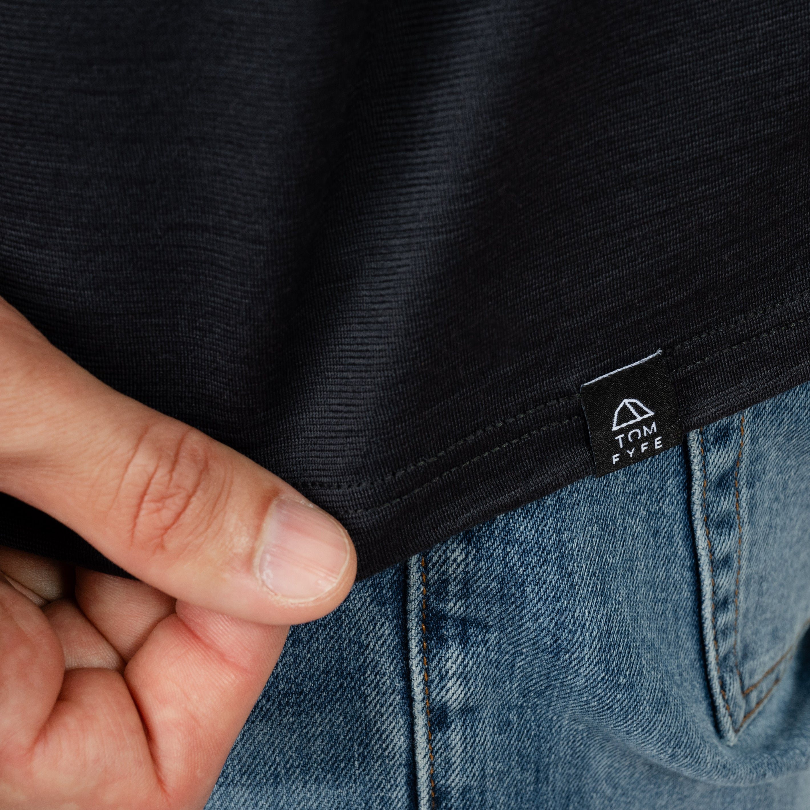 Model mit Merino Herren Poloshirt Label von Tom Fyfe in Anthrazit