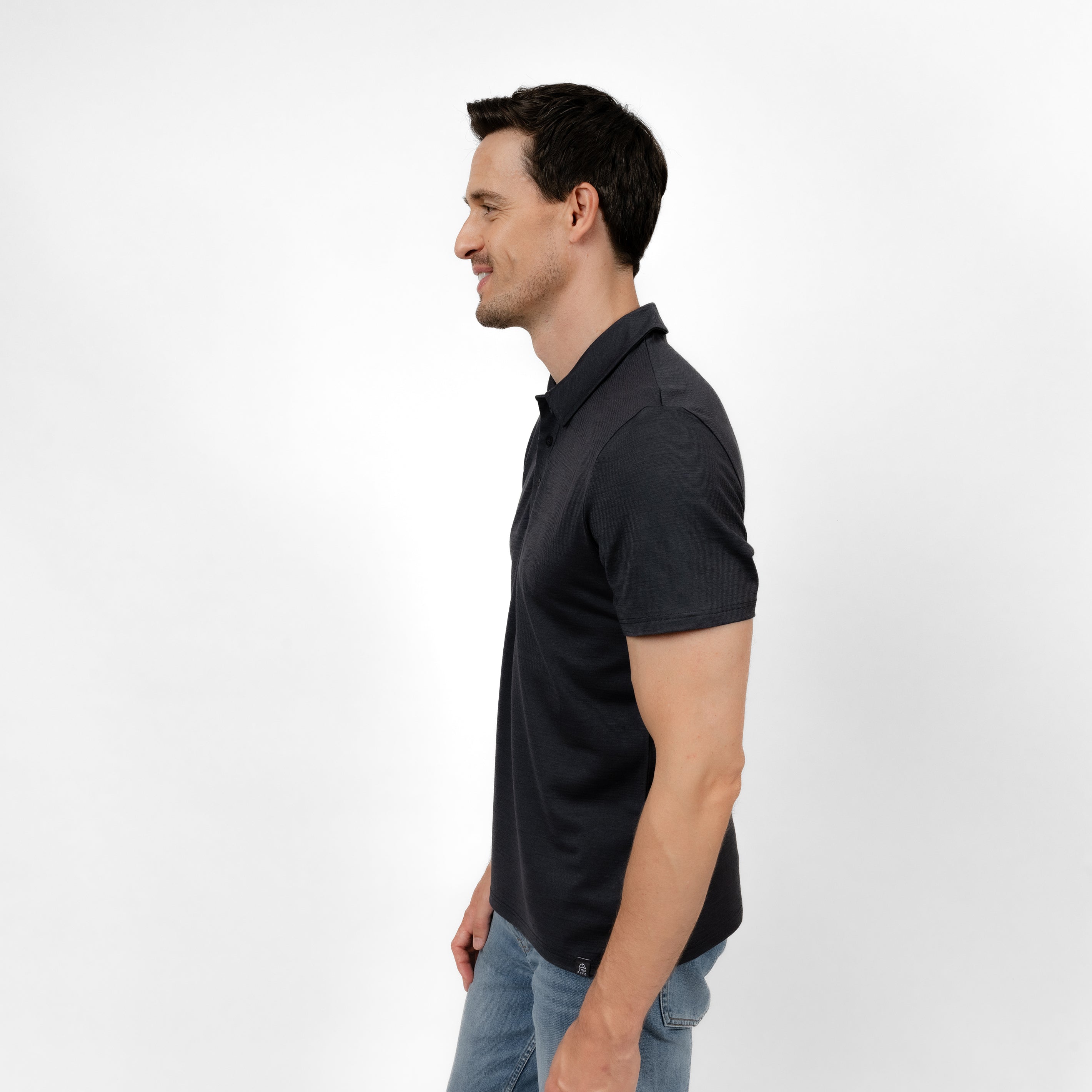 Model mit Merino Herren Poloshirt Seitenansicht von Tom Fyfe in Anthrazit