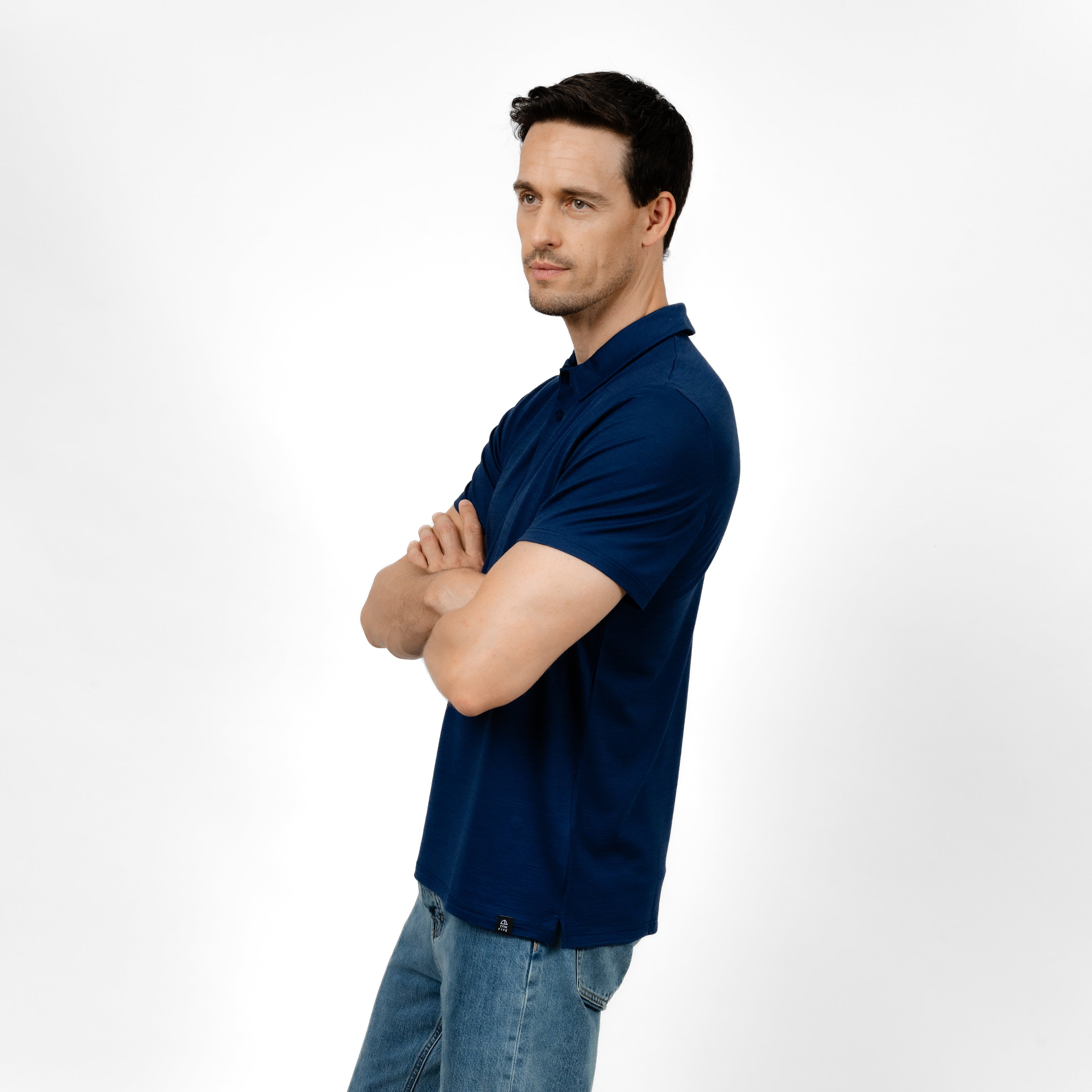 Model mit Merino Herren Poloshirt Seitenansicht von Tom Fyfe in Marine