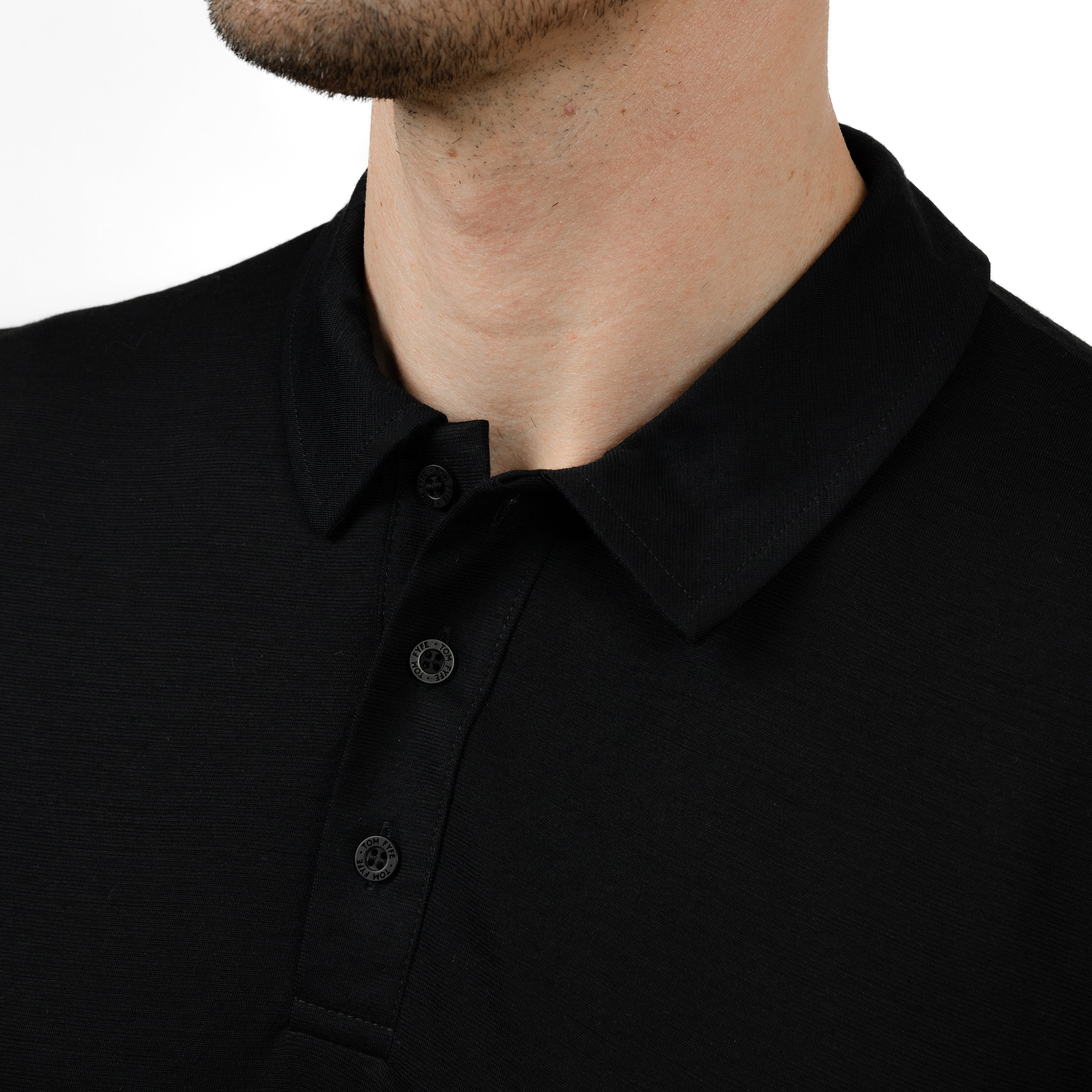 Model mit Merino Herren Poloshirt Kragenbereich von Tom Fyfe in Schwarz