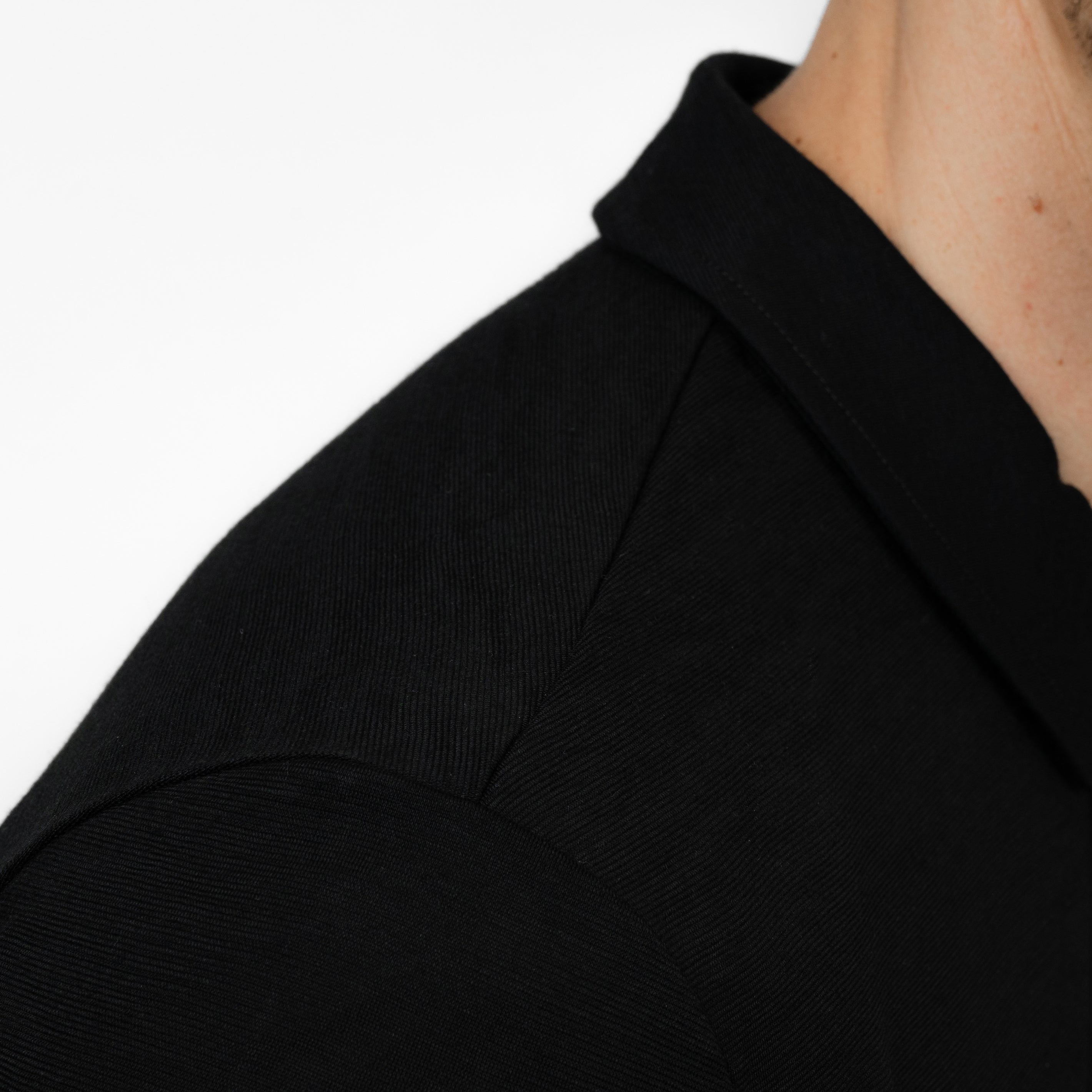 Model mit Merino Herren Poloshirt Nahaufnahme von Tom Fyfe in Schwarz