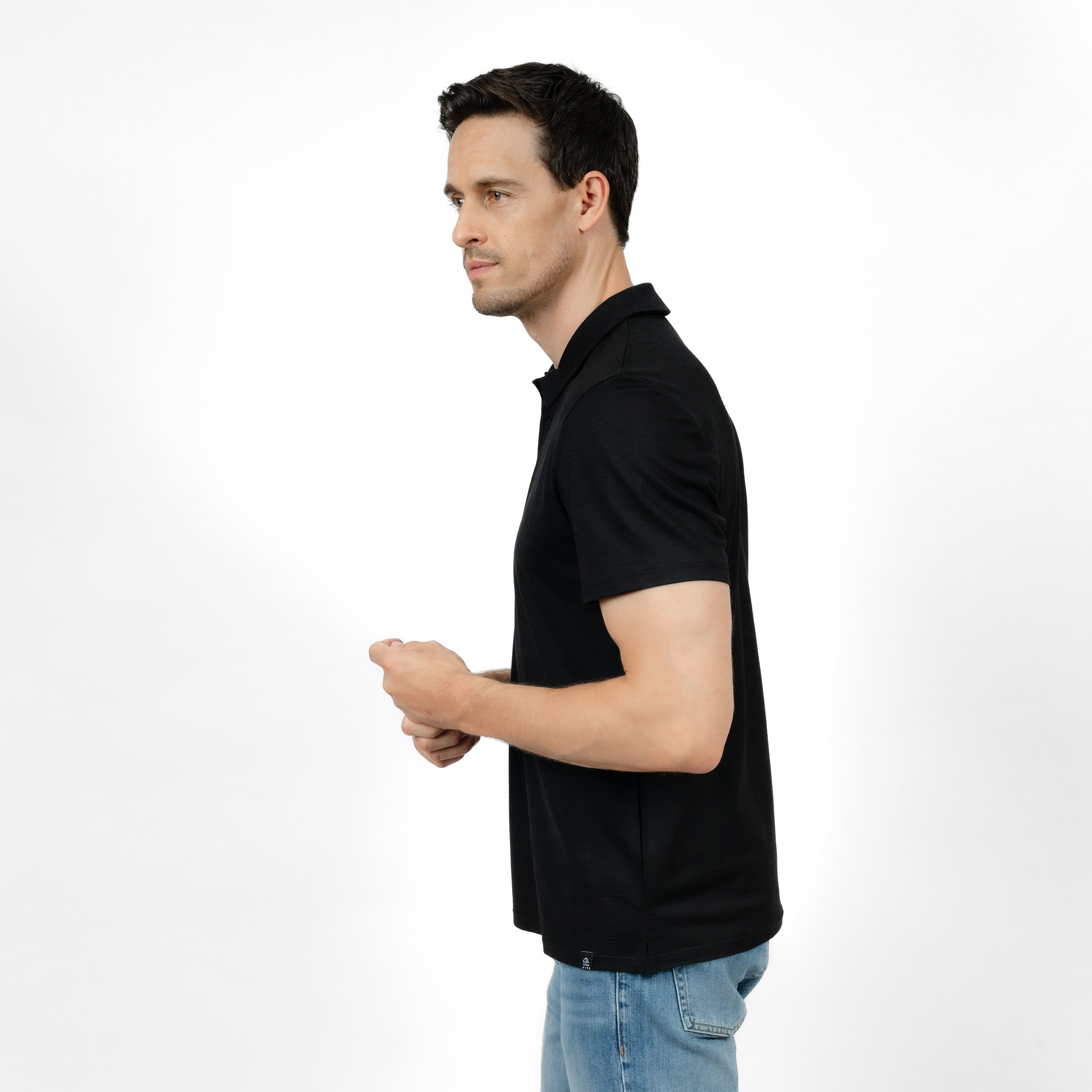 Model mit Merino Herren Poloshirt Seitenansicht von Tom Fyfe in Schwarz