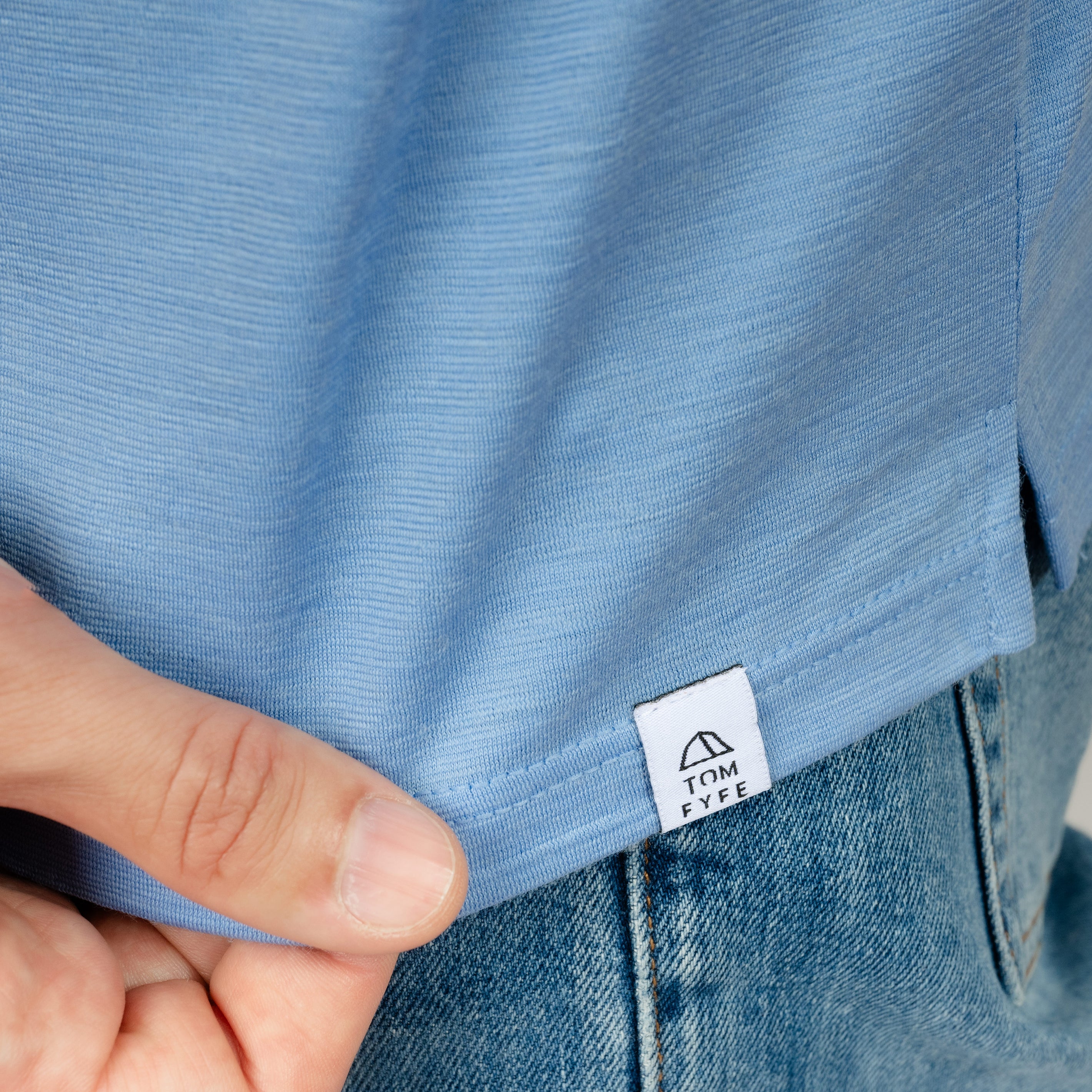 Model mit Merino Herren Poloshirt Label von Tom Fyfe in Steelblue