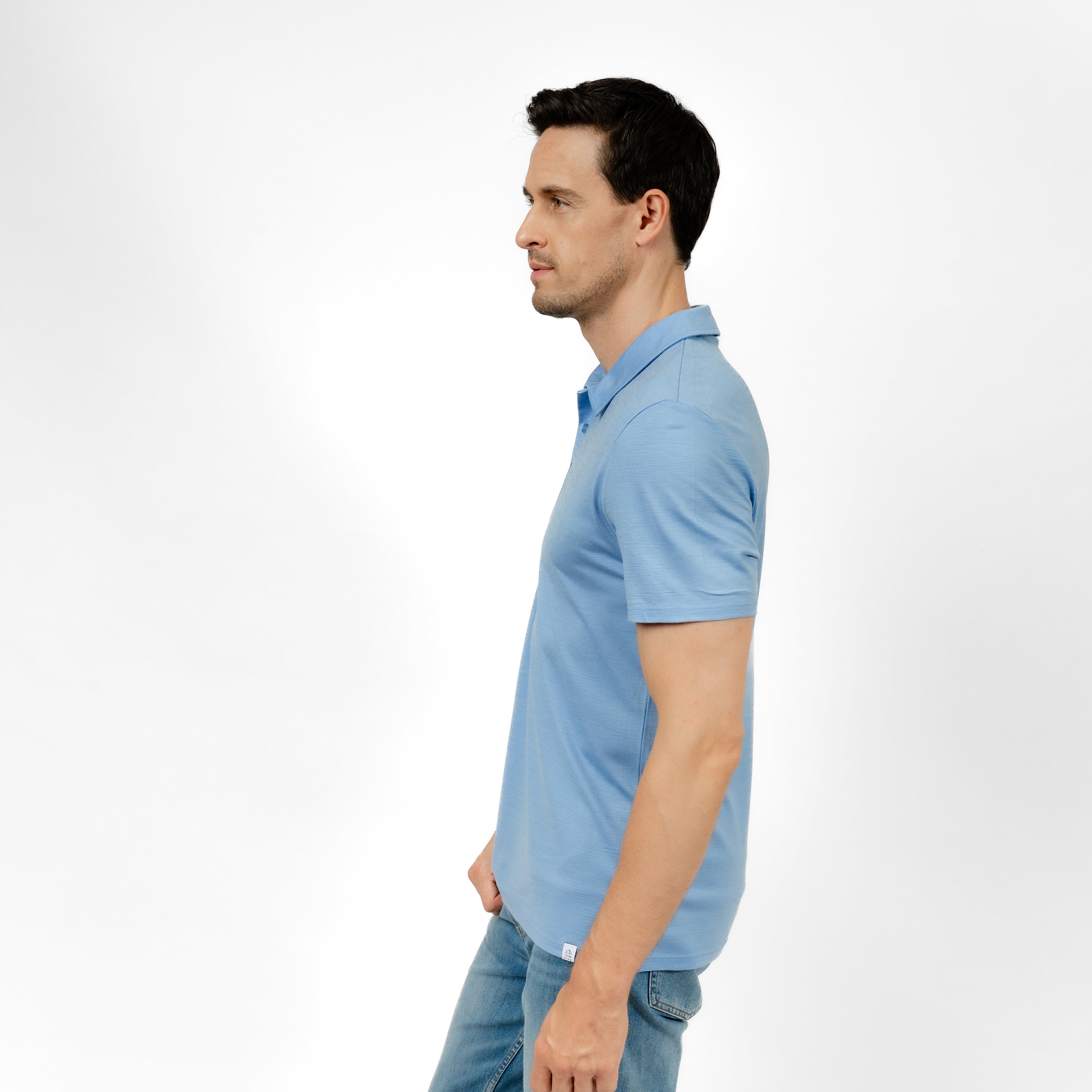 Model mit Merino Herren Poloshirt Seitenansicht von Tom Fyfe in Steelblue