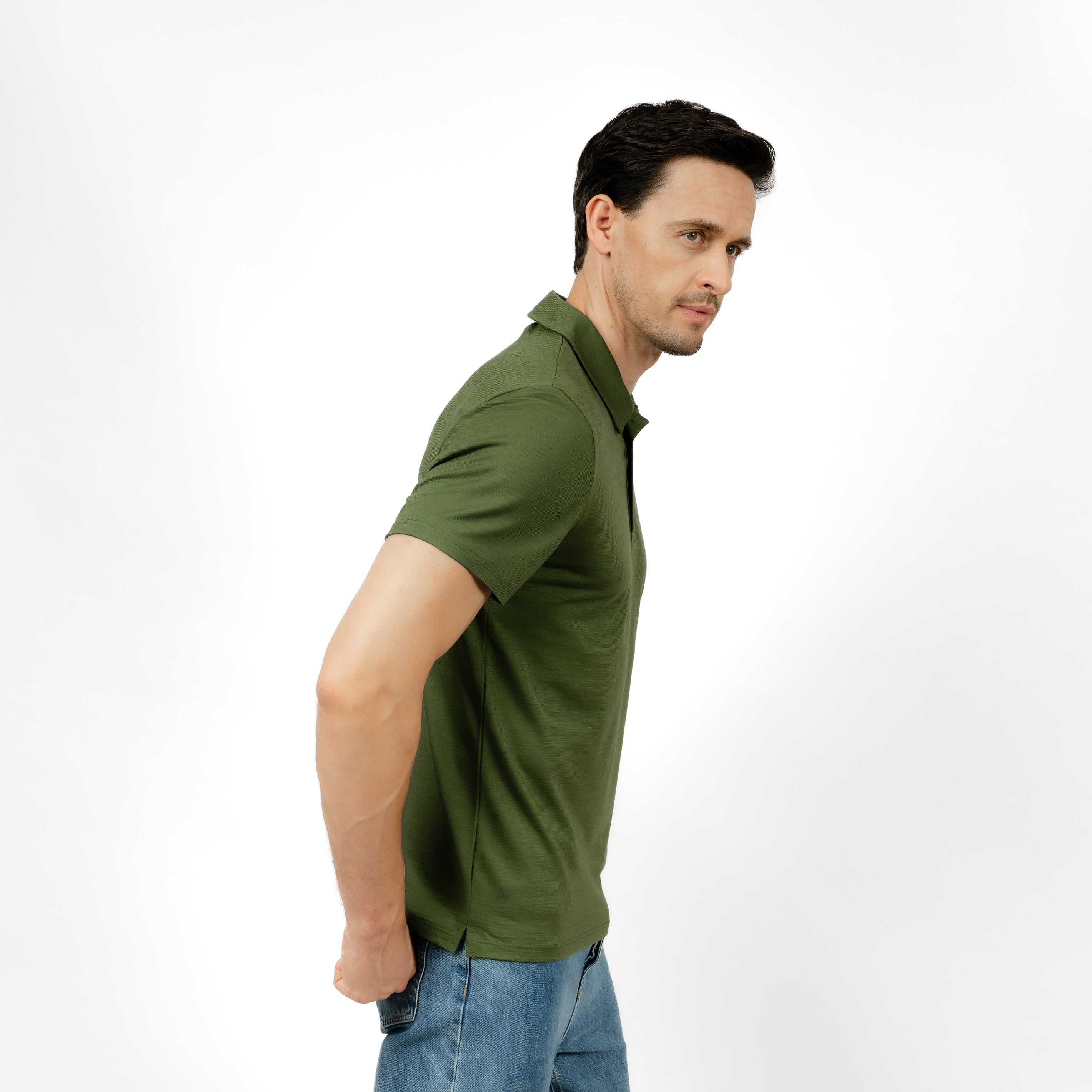 Model mit Merino Herren Poloshirt Seitenansicht von Tom Fyfe in Waldgruen