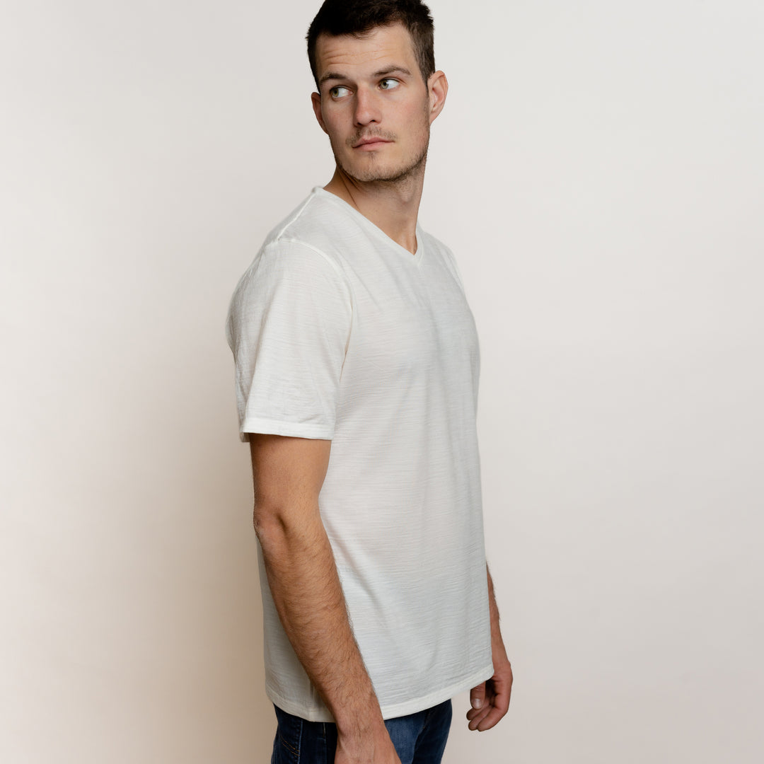 Männliches Model im Merino Herren Shirt mit V-Ausschnitt Seitenansicht von Tom Fyfe in Wollweiss #farbe_wollweiss