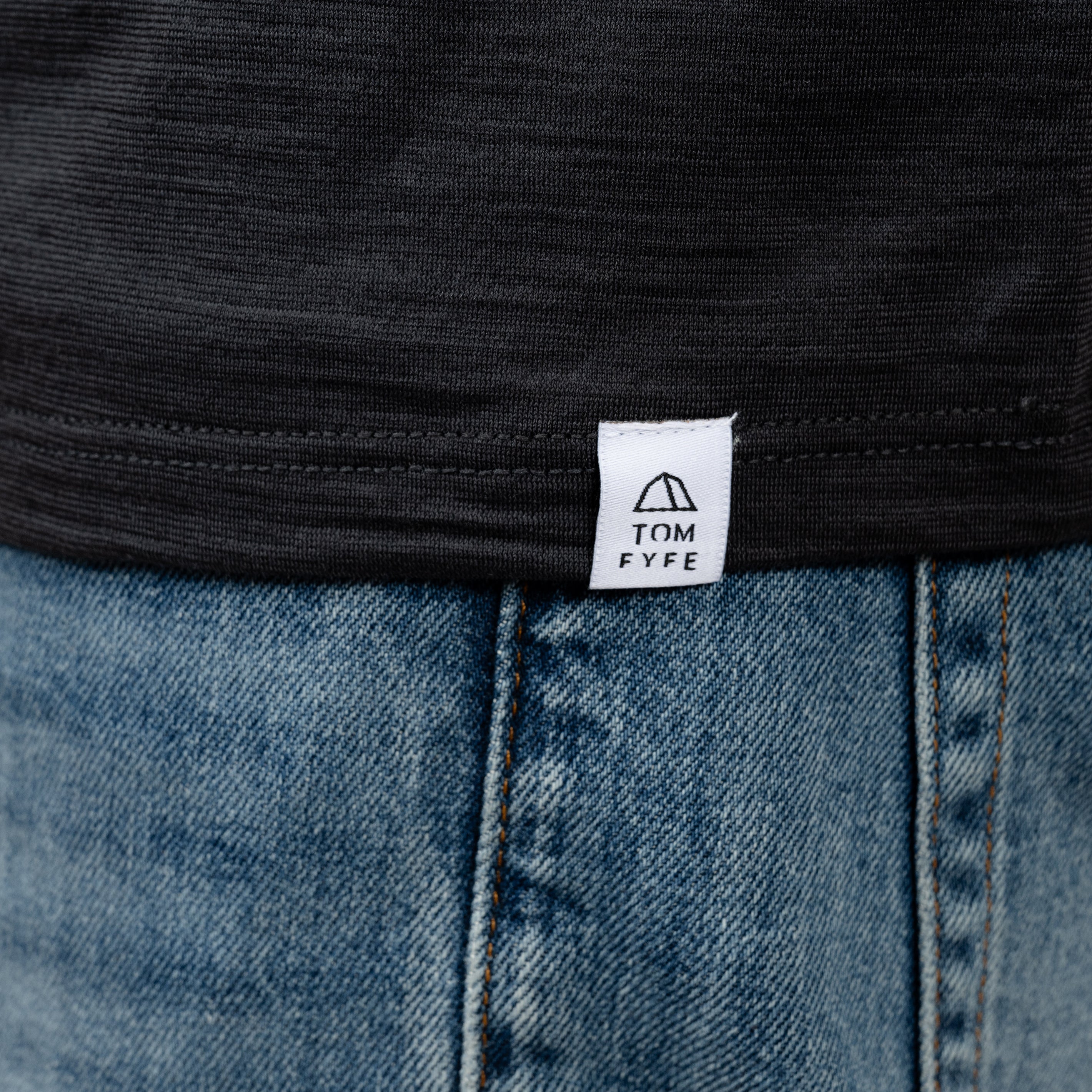 Model mit Merino T-Shirt Regular Fit Unisex mit angenaehtem Stofflabel mit Logo von Tom Fyfe in Anthrazit