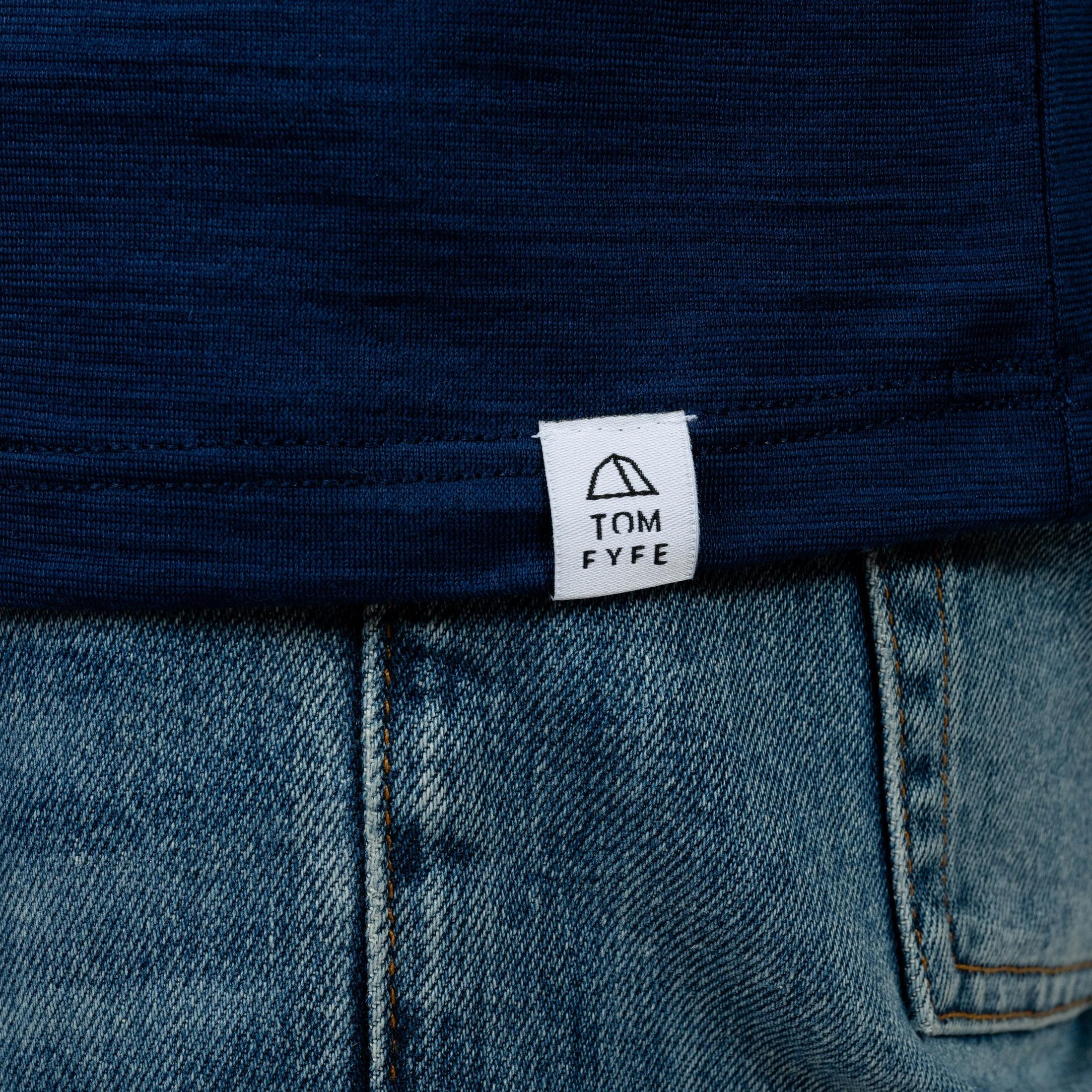 Model mit Merino T-Shirt Regular Fit Unisex mit angenaehtem Stofflabel mit Logo von TOM FYFE in Marine