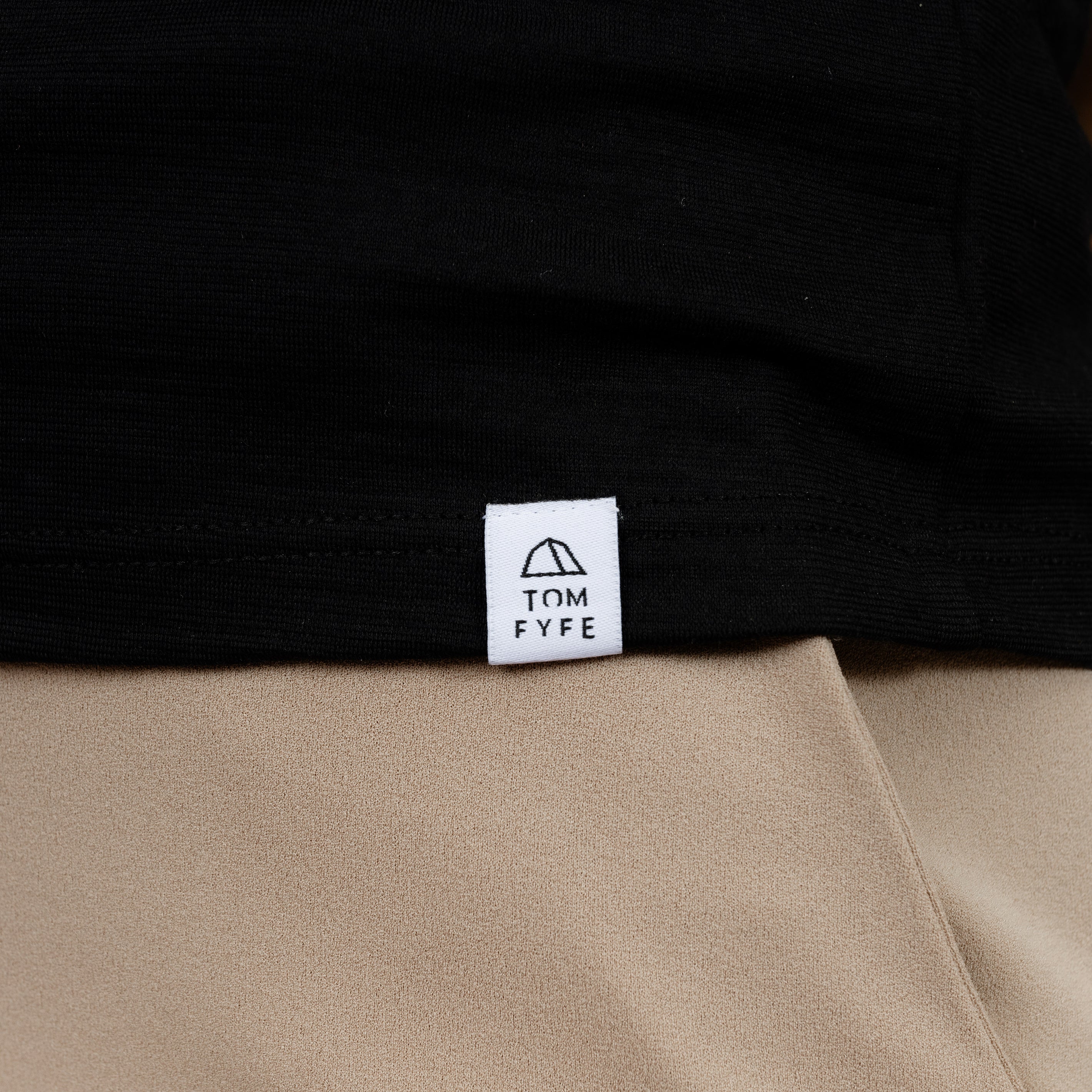 Model mit Merino T-Shirt Regular Fit Unisex mit angenaehtem Stofflabel mit Logo von Tom Fyfe in Schwarz