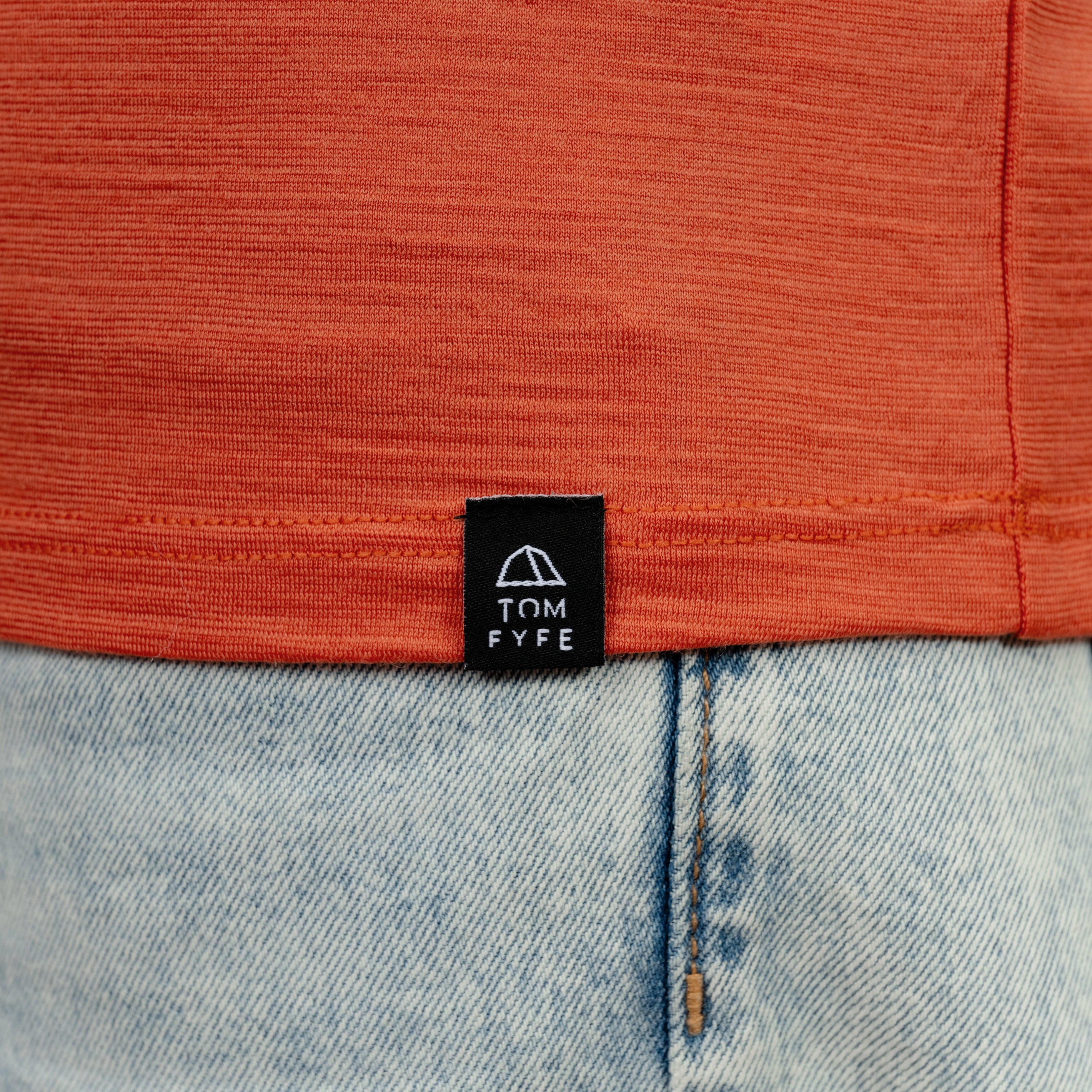 Model mit Merino T-Shirt Regular Fit Unisex mit angenaehtem Stofflabel mit Logo von Tom Fyfe in Terracotta
