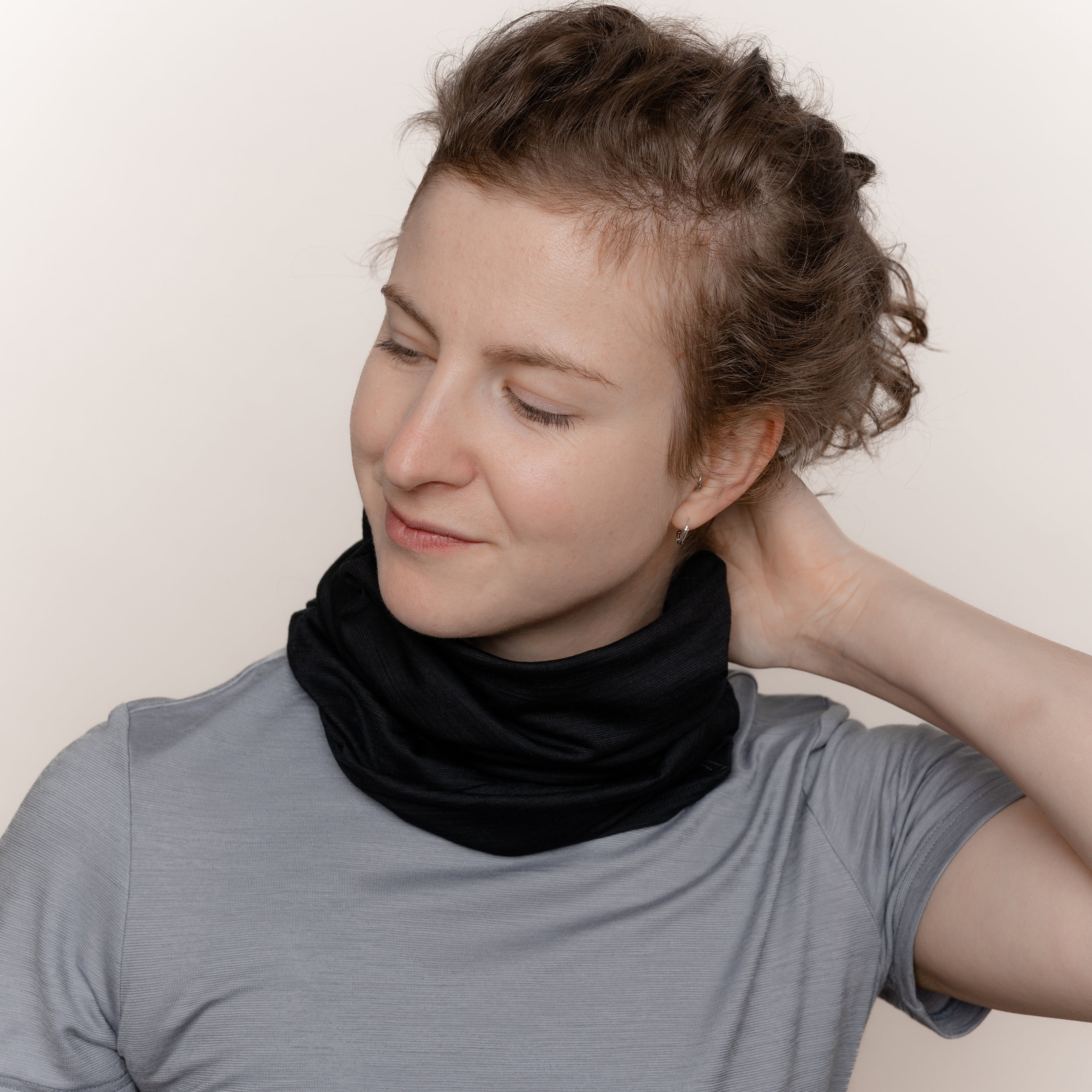Weibliches Model mit Merino Schlauchschal Multifunktionstuch von Tom Fyfe in Schwarz als Halstuch