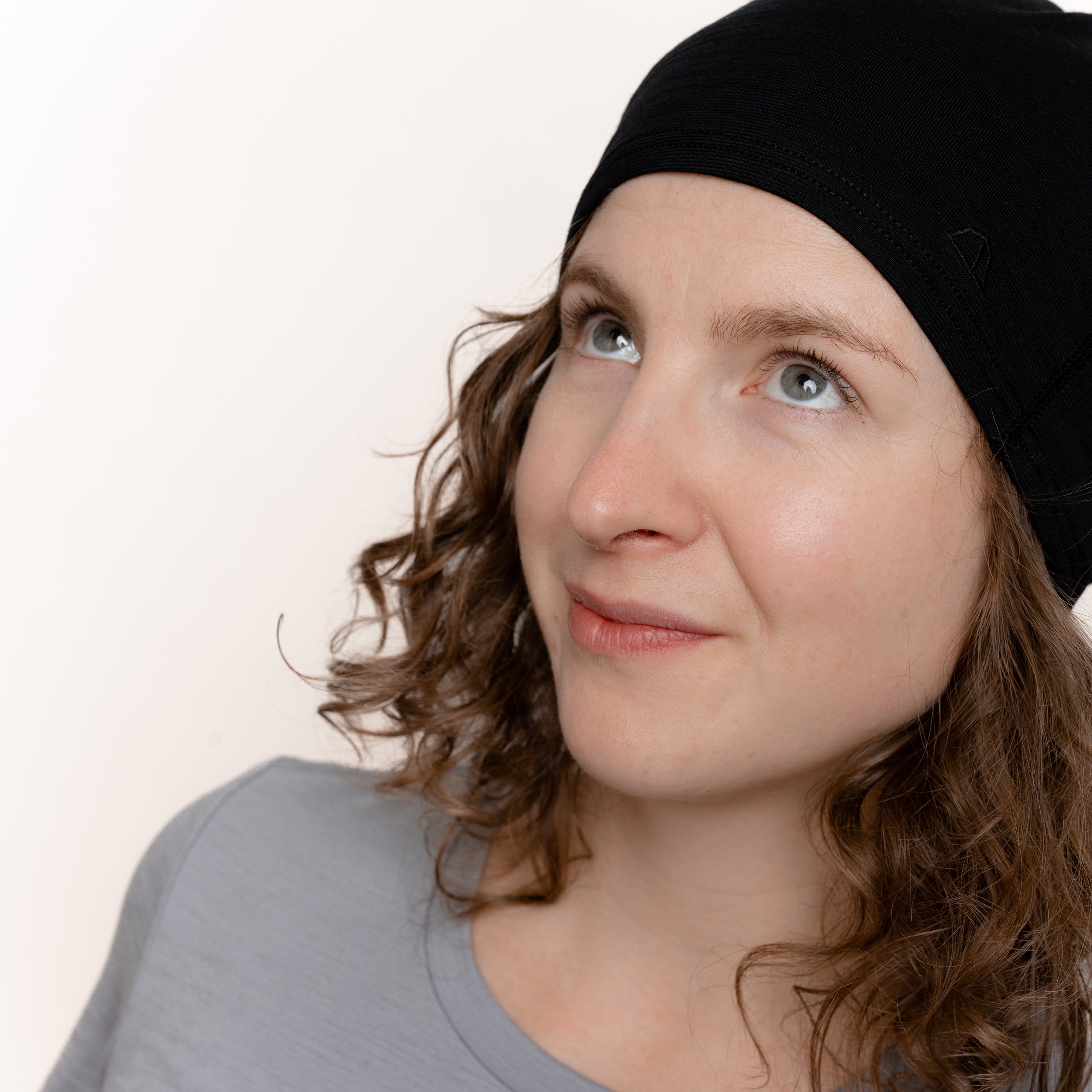 Weibliches Model mit Merino Schlauchschal Multifunktionstuch von Tom Fyfe in Schwarz