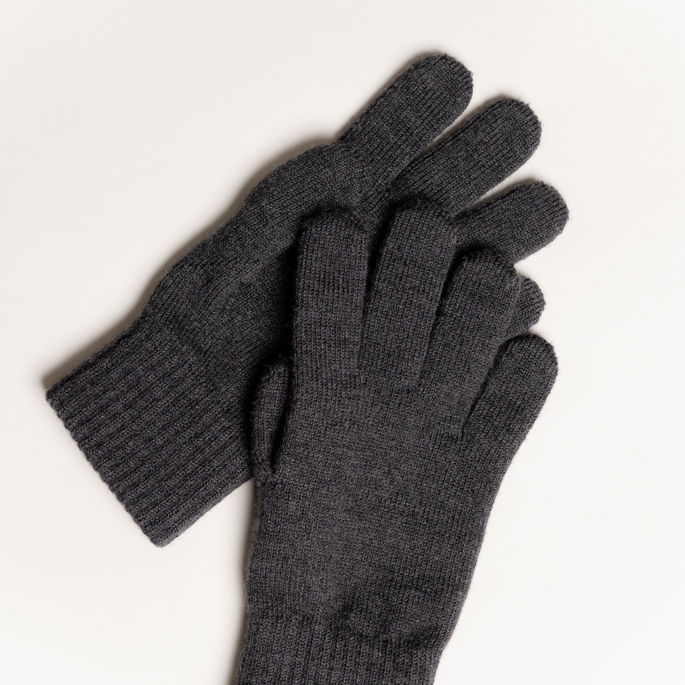 Die gestrickten Handschuhe aus Merinowolle in der Farbe Anthrazit sorgen für Wärme und Komfort