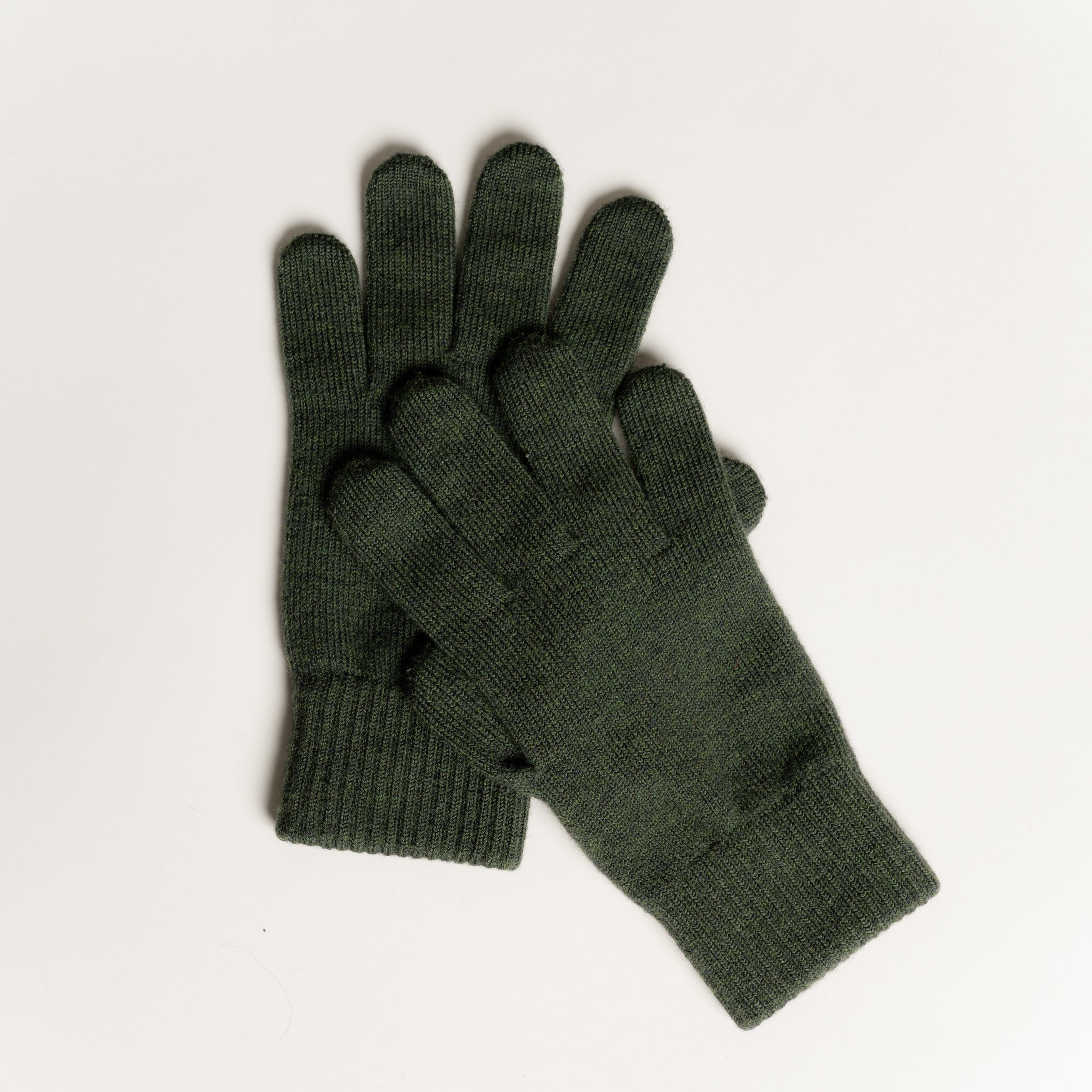 Die gestrickten Handschuhe aus Merinowolle in der Farbe Dunkelgrün sorgen für Wärme und Komfort