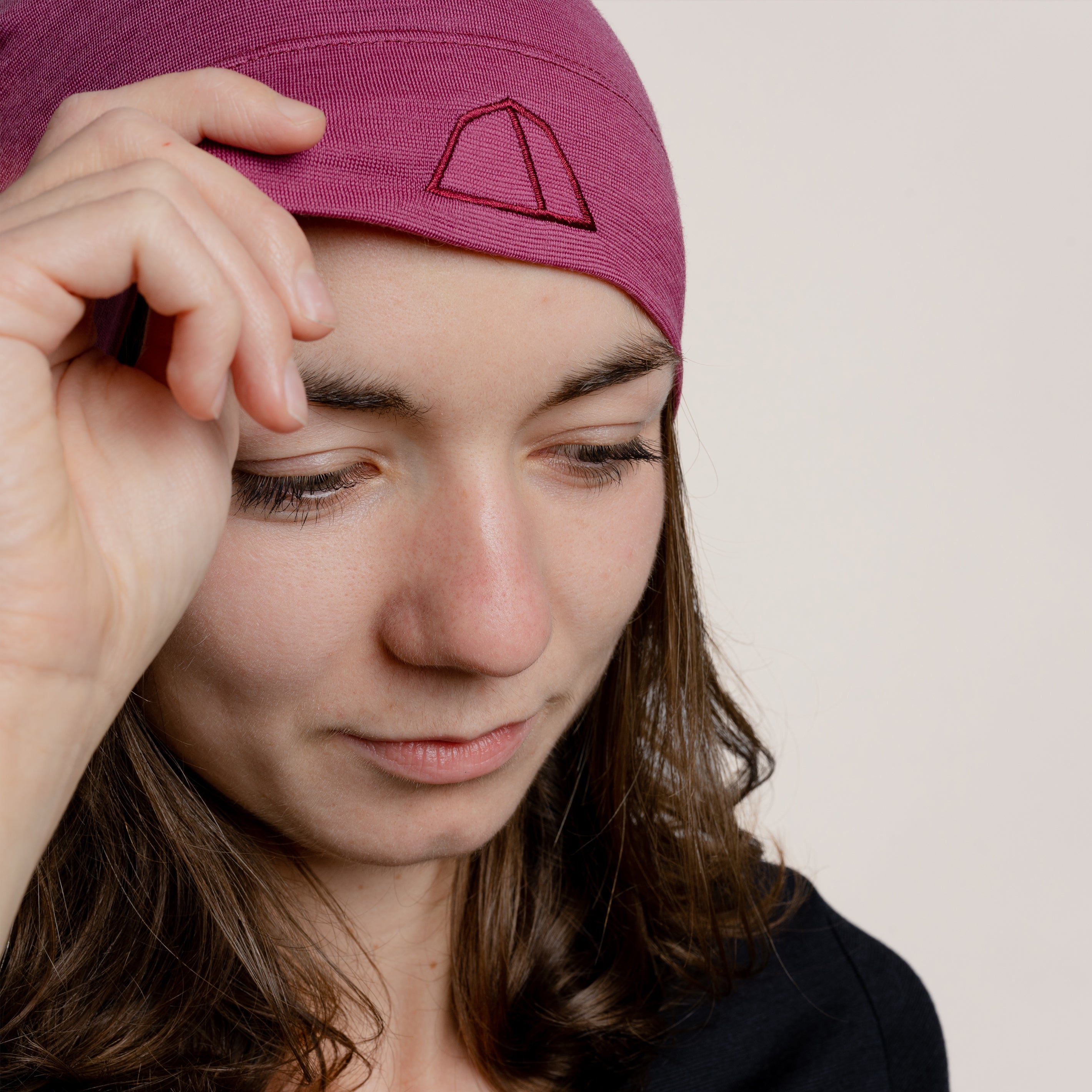 Weibliches Model mit Merino Beanie Muetze dehnbar von Tom Fyfe in Brombeere