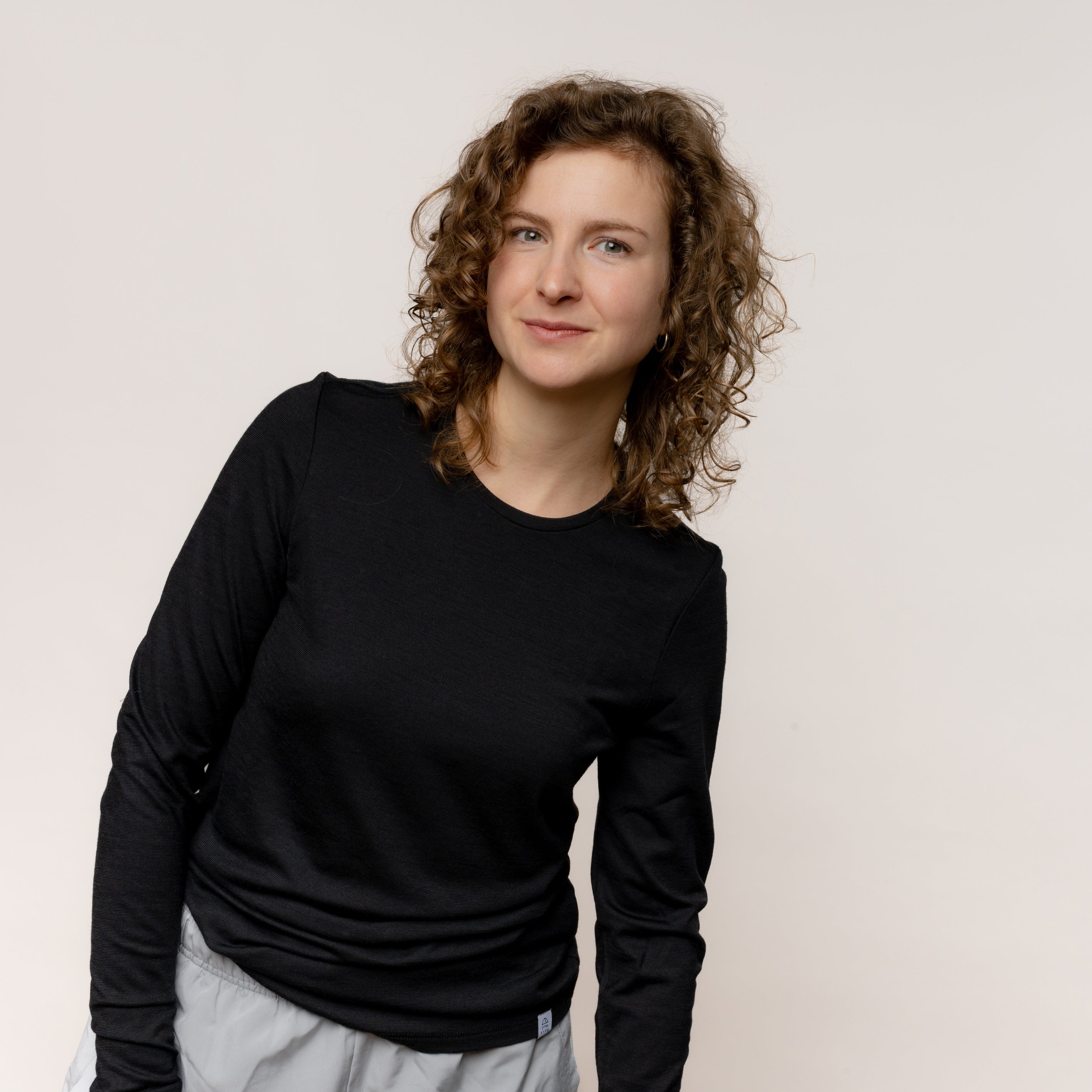 Weibliches Model mit stylischem Merino Damen Longsleeve von TOM FYFE in Schwarz