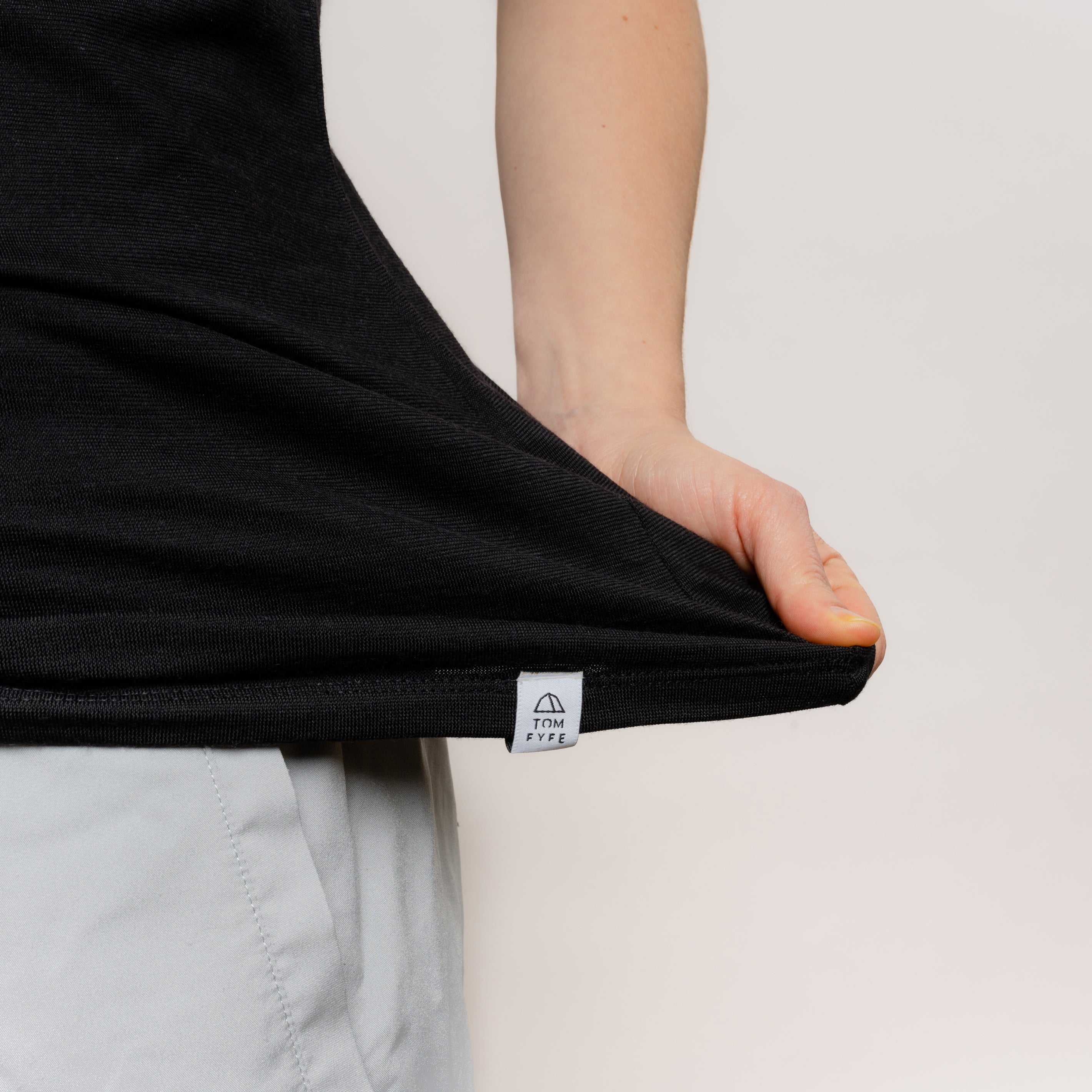 Model mit Merino Damen Shirt mit V-Ausschnitt mit angenaehtem Stofflabel von Tom Fyfe in Schwarz