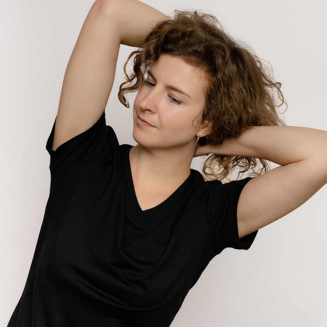 Model mit Merino Damen Shirt mit V-Ausschnitt Frontansicht Nahaufnahme von Tom Fyfe in Schwarz #farbe_schwarz