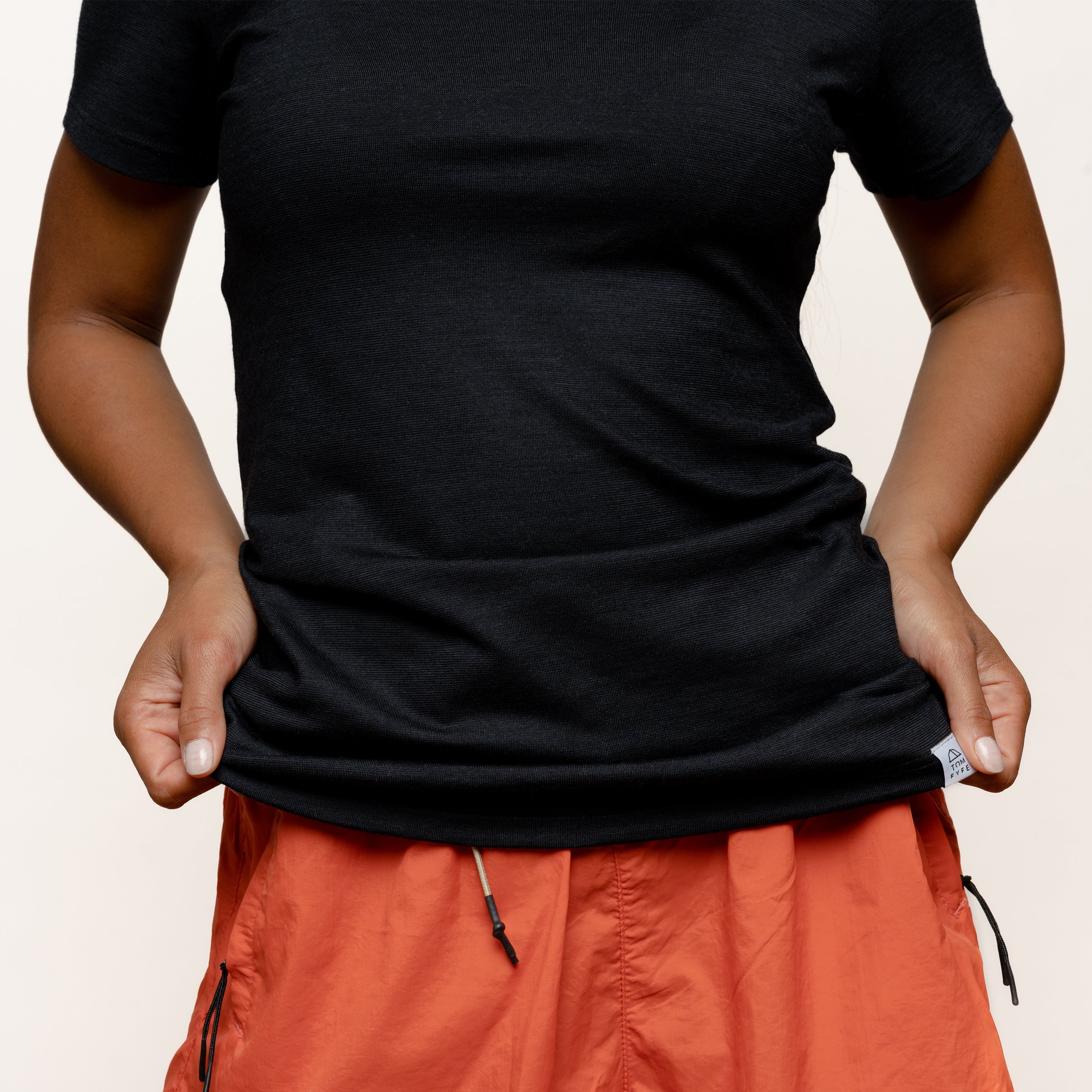 Model mit Merino Damen Shirt mit angenaehtem Stofflabel mit Logo von Tom Fyfe in Schwarz