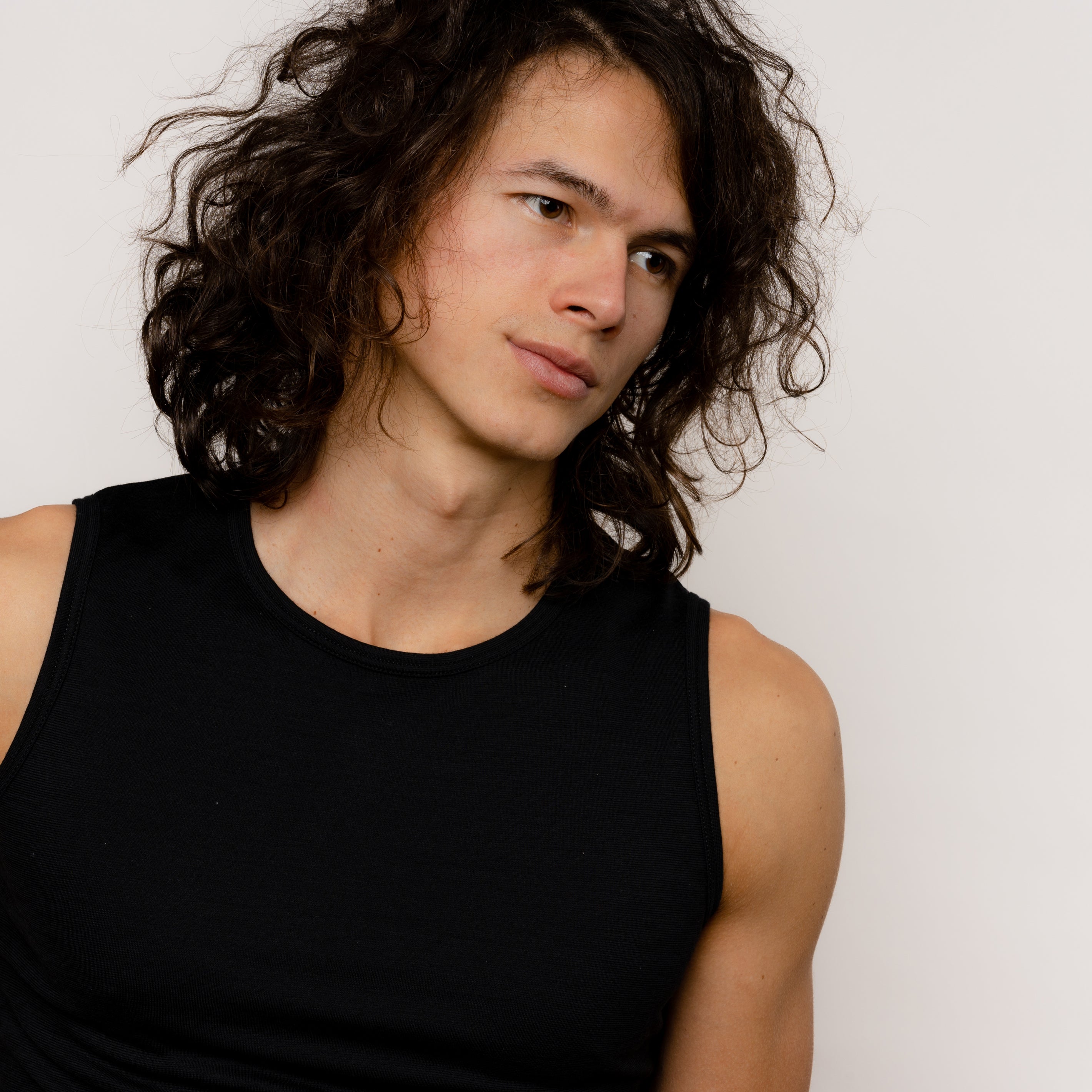 Model mit Merino Herren Tanktop Frontansicht Nahaufnahme seitlich von Tom Fyfe in Schwarz