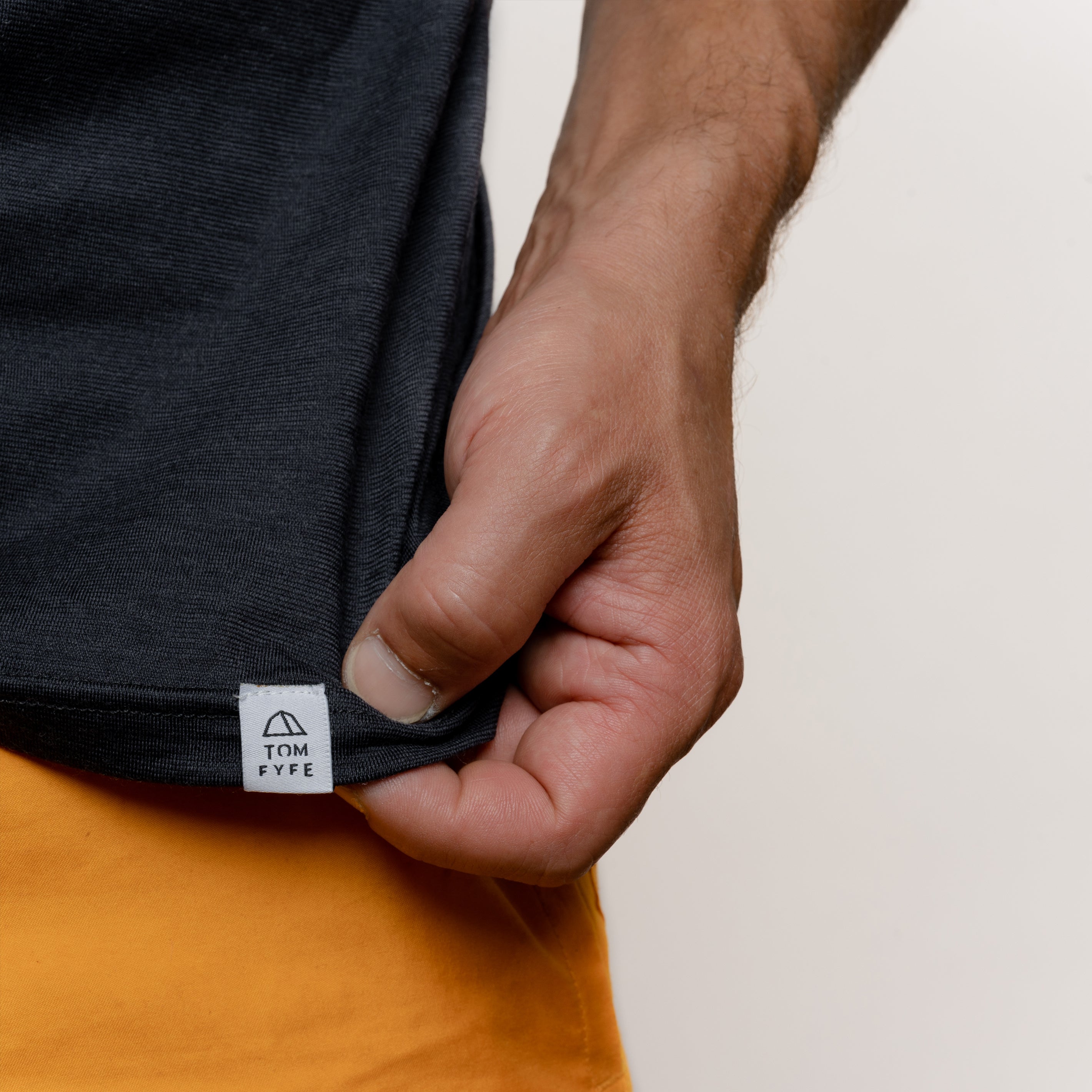 Model mit Merino Herren Shirt mit angenaehtem Stofflabel mit Logo von TOM FYFE in Anthrazit