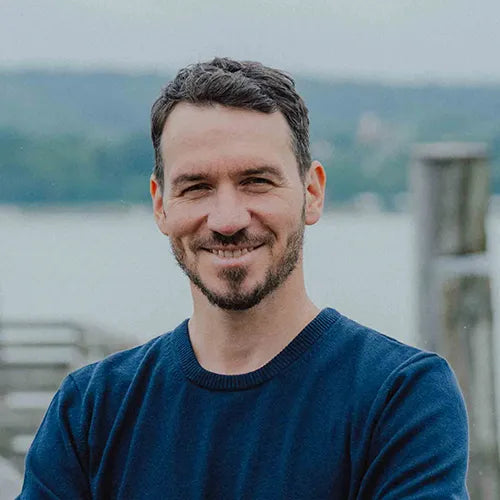 Felix Neureuther im TOM FYFE Merino Pullover Herren in Marine als Portrait am See.