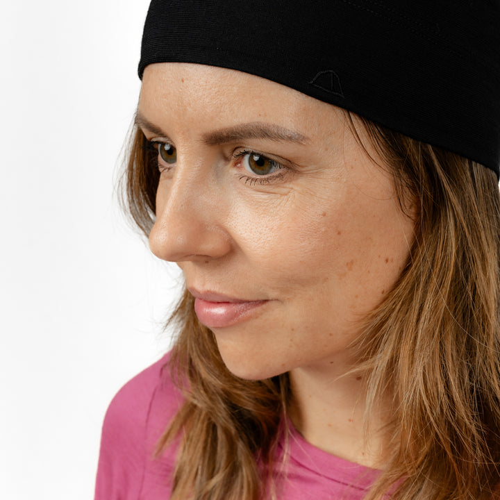 Weibliches Model Seitenansicht mit Merino Beanie Muetze von Tom Fyfe in Schwarz #farbe_schwarz