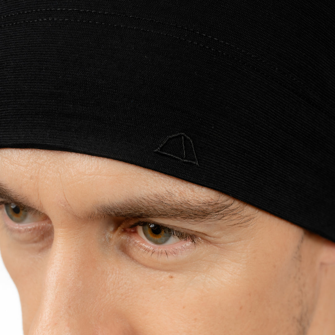 Männliches Model mit Merino Beanie Muetze Nahansicht von Tom Fyfe in Schwarz #farbe_schwarz