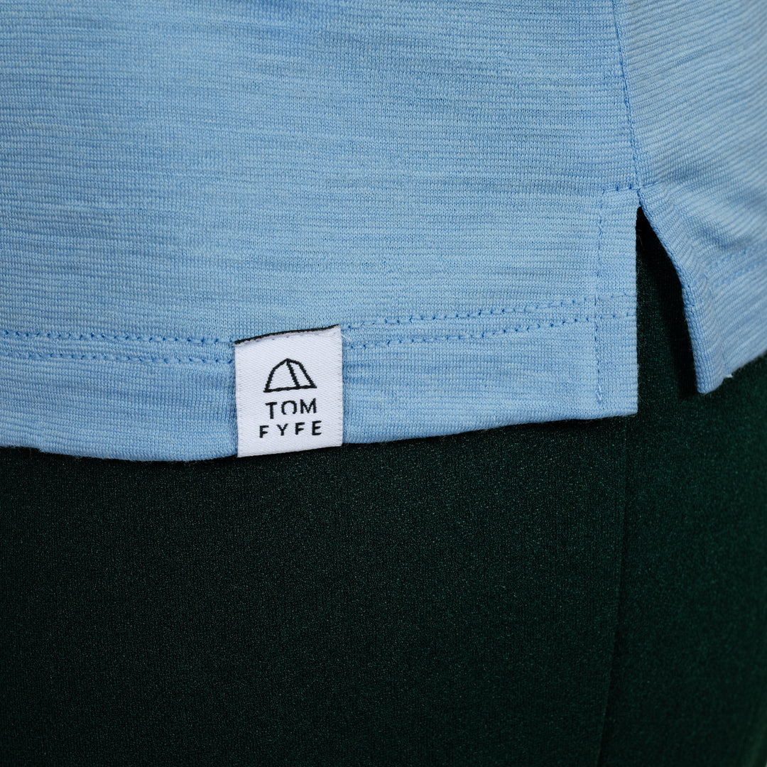 Model mit Merino Damen Poloshirt Label von Tom Fyfe in Steelblue #farbe_steel-blue