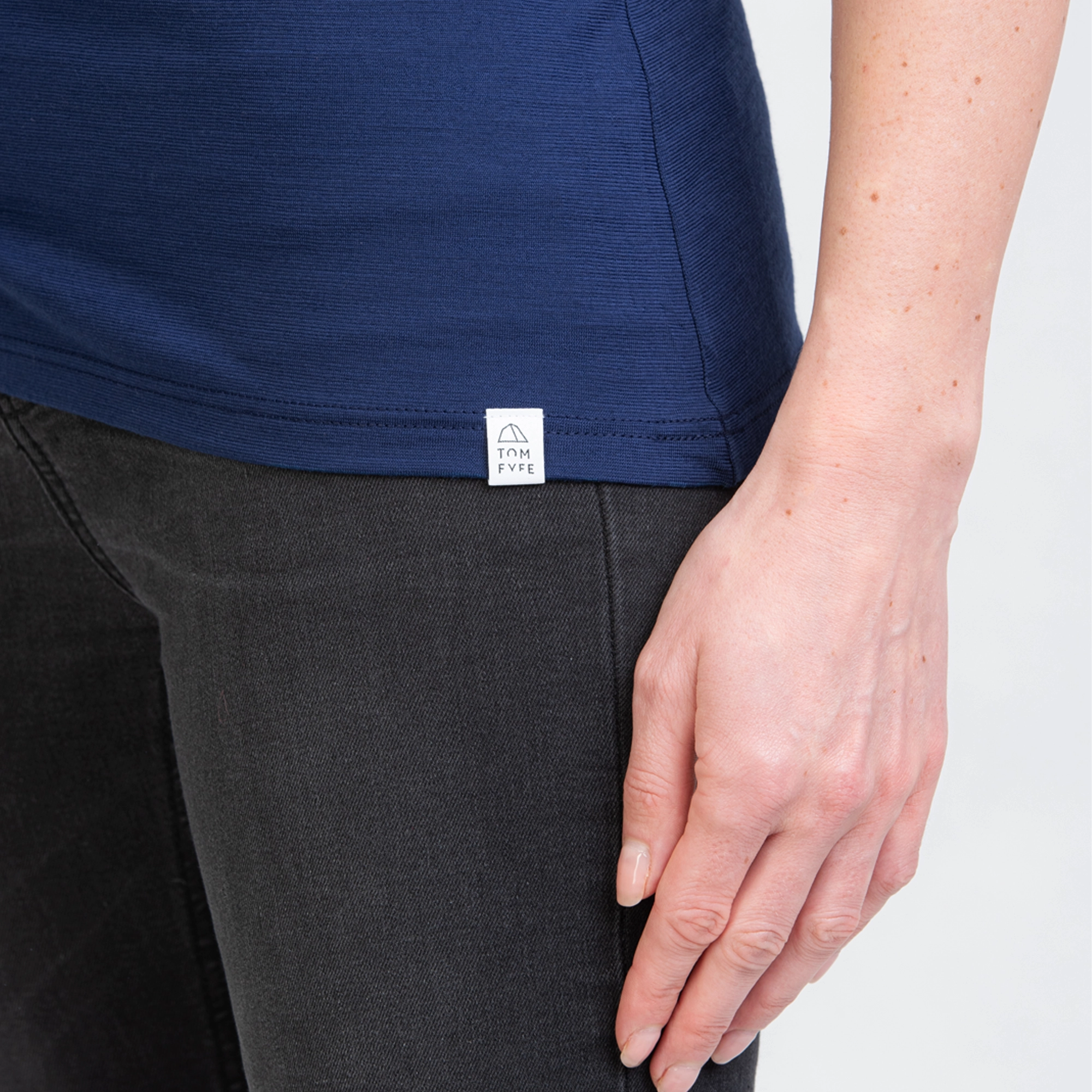 Model mit Merino Damen Shirt mit angenaehtem Stofflabel mit Logo von TOM FYFE in Marineblau 