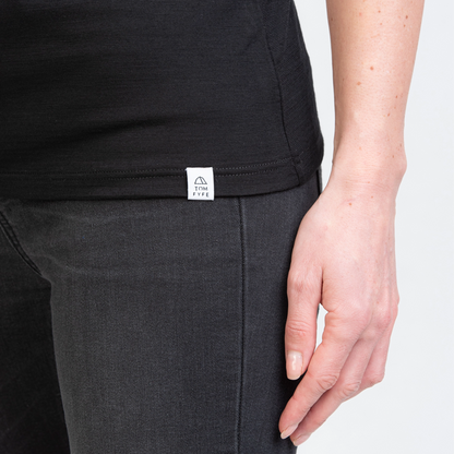 Model mit Merino Damen Shirt mit angenaehtem Stofflabel mit Logo von TOM FYFE in Schwarz 
