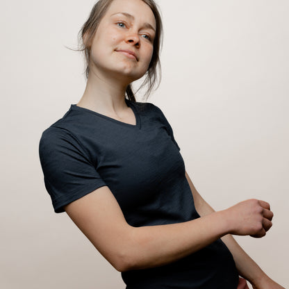 Model mit Merino Damen Shirt mit V-Ausschnitt von Tom Fyfe in Anthrazit Seitenansicht in Bewegung 