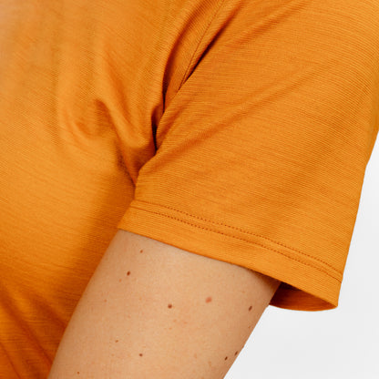 Model mit Merino Damen Shirt mit V-Ausschnitt von Tom Fyfe Nahaufnahme Ärmel in Kurkuma 