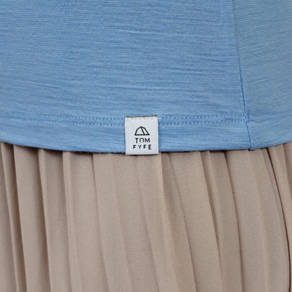 Model mit Merino Damen Shirt mit V-Ausschnitt von TOM FYFE Saum mit angenähtem Logo in Steelblue 